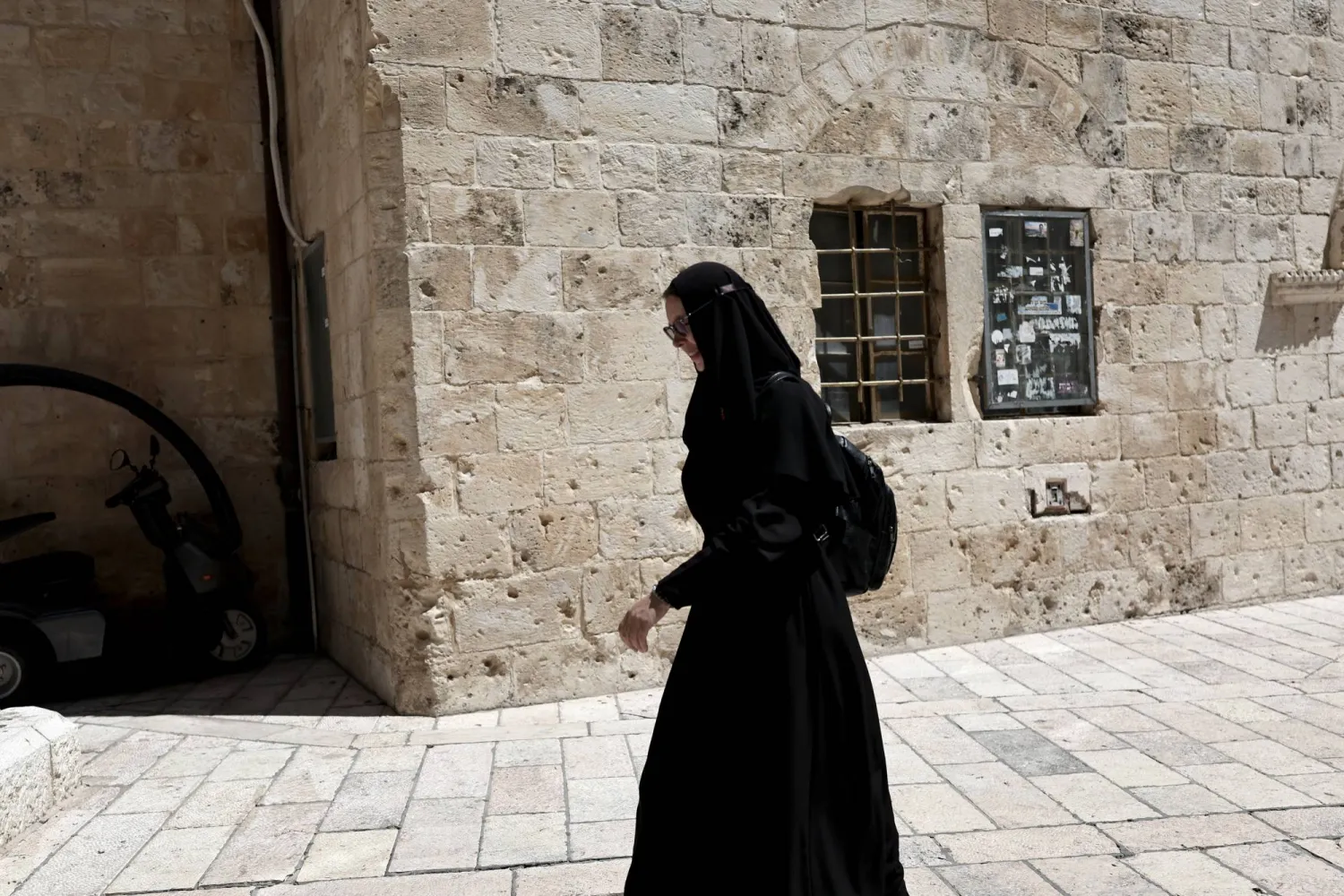 راهبة تمر بالقرب من البلدة القديمة في القدس (إ.ب.أ)
