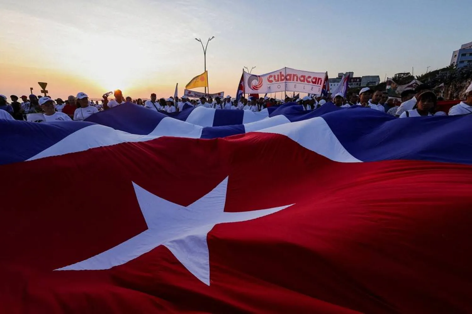 People march while holding a giant Cuban national flag during a May Day rally in Havana, Cuba, May 1, 2026. (Reuters)