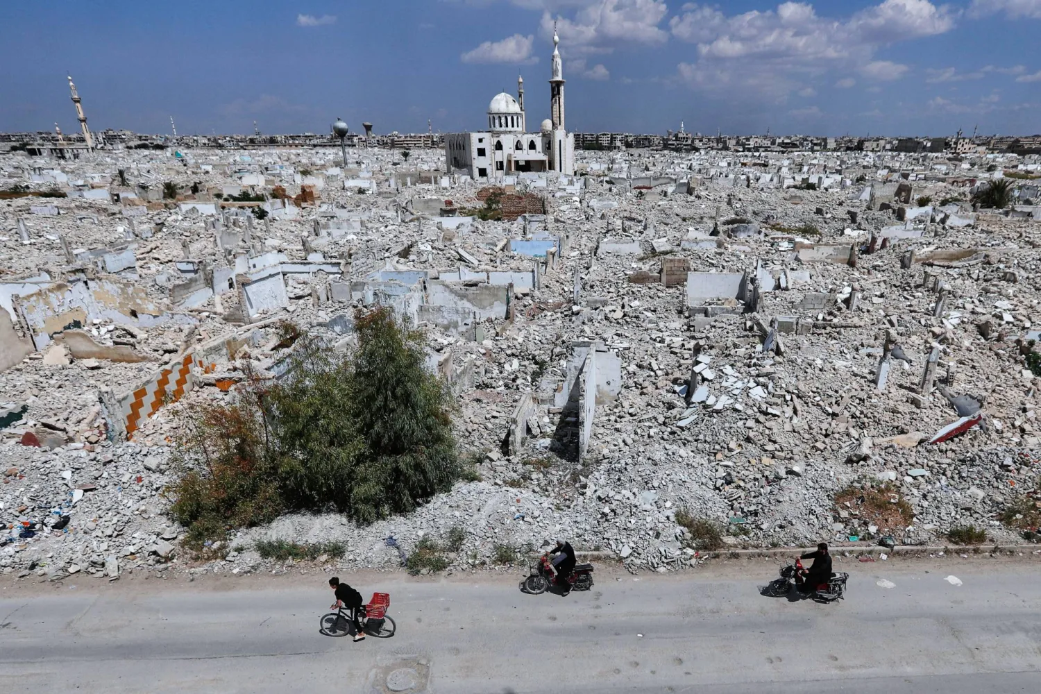 Motorcyclists pass destruction in the al-Qadam area on the outskirts of Damascus, Syria, Wednesday, April 29, 2026 in a area that was heavily bombed by forces loyal to former Syrian president Bashar Assad during the Syrian war. (AP Photo/Omar Sanadiki)