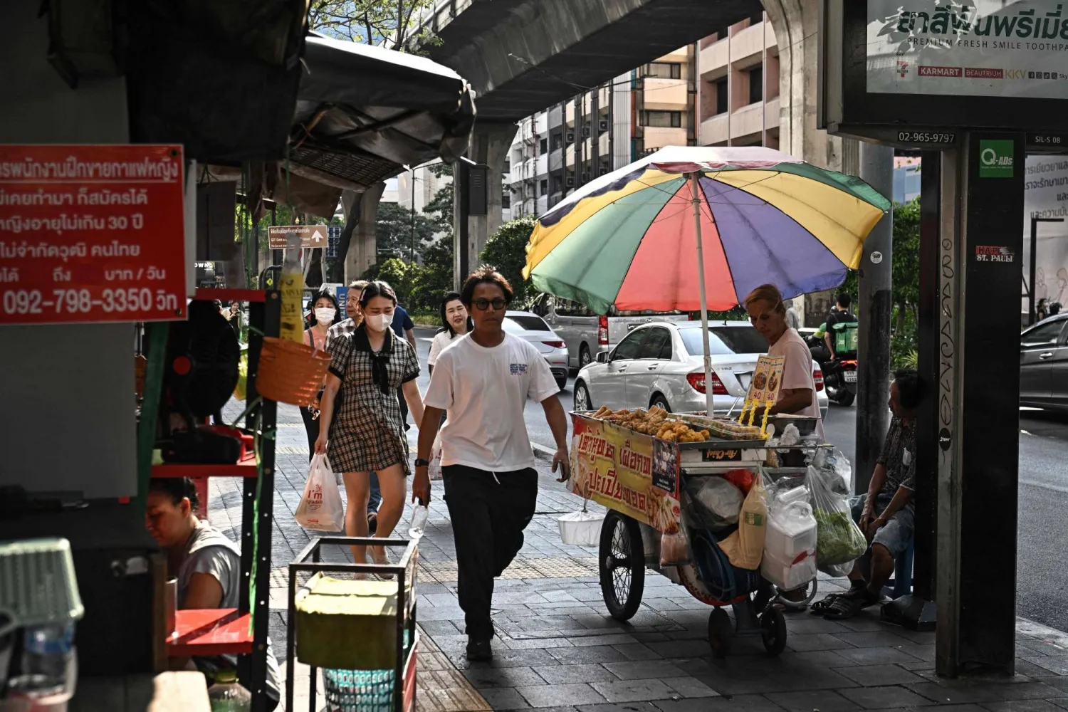 This photo taken on April 30, 2026 shows a street vendor selling fried food along Silom road in Bangkok. (Photo by Lillian SUWANRUMPHA / AFP) 