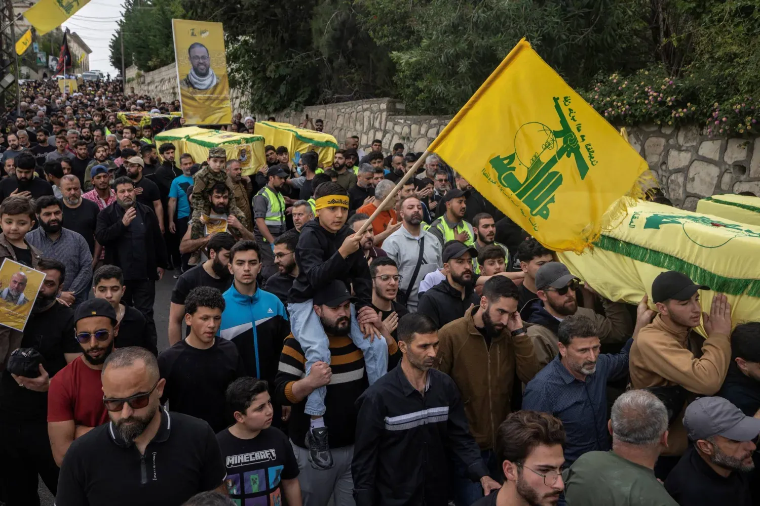 Lübnan'ın güneyinde bazı Hizbullah üyelerinin ve sivillerin cenaze töreninde taşınan Hizbullah bayrakları (Reuters)