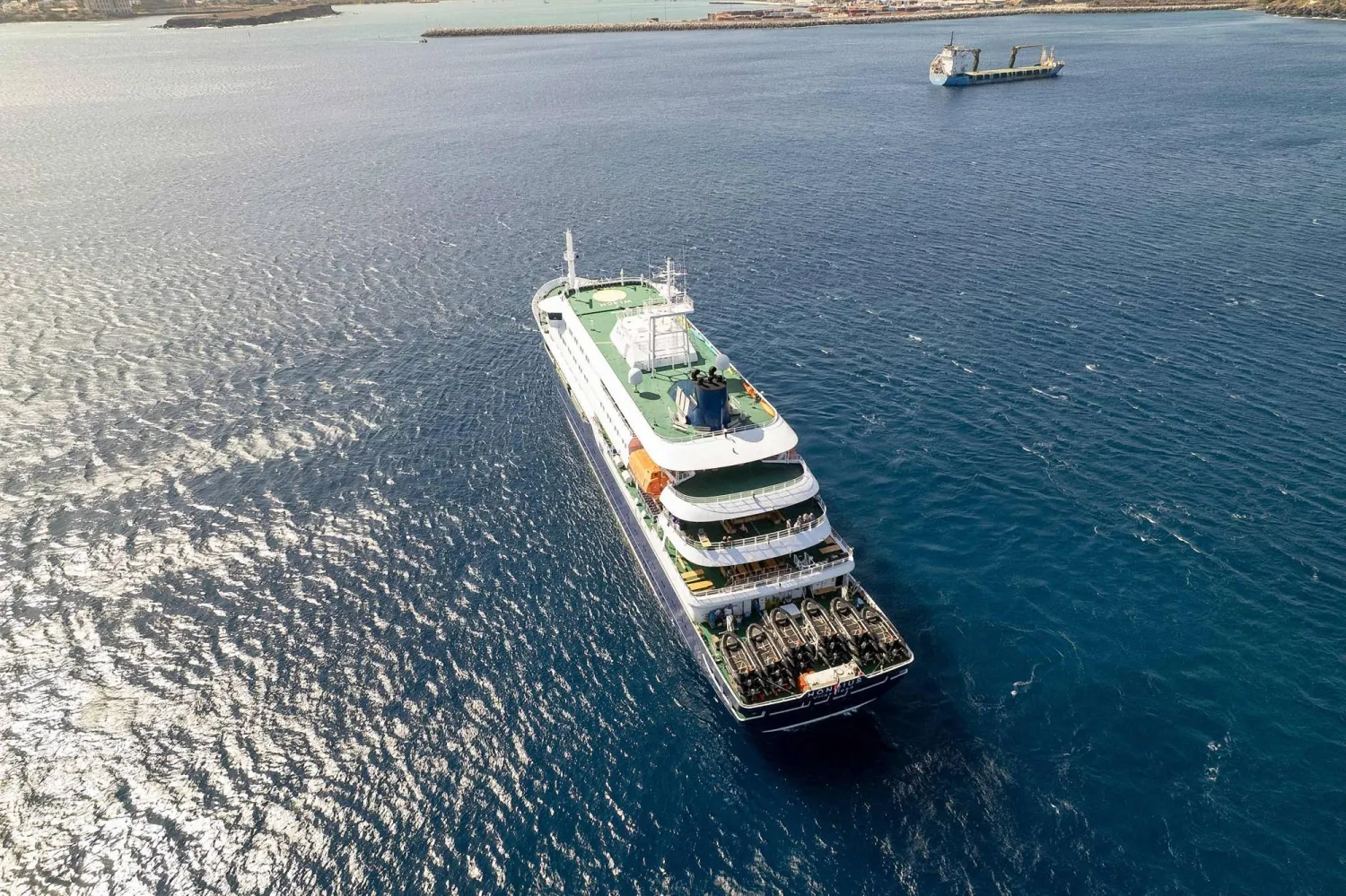 This aerial picture shows a general view of the cruise ship MV Hondius stationary off the port of Praia, the capital of Cape Verde, on May 3, 2025. (Photo by AFP)