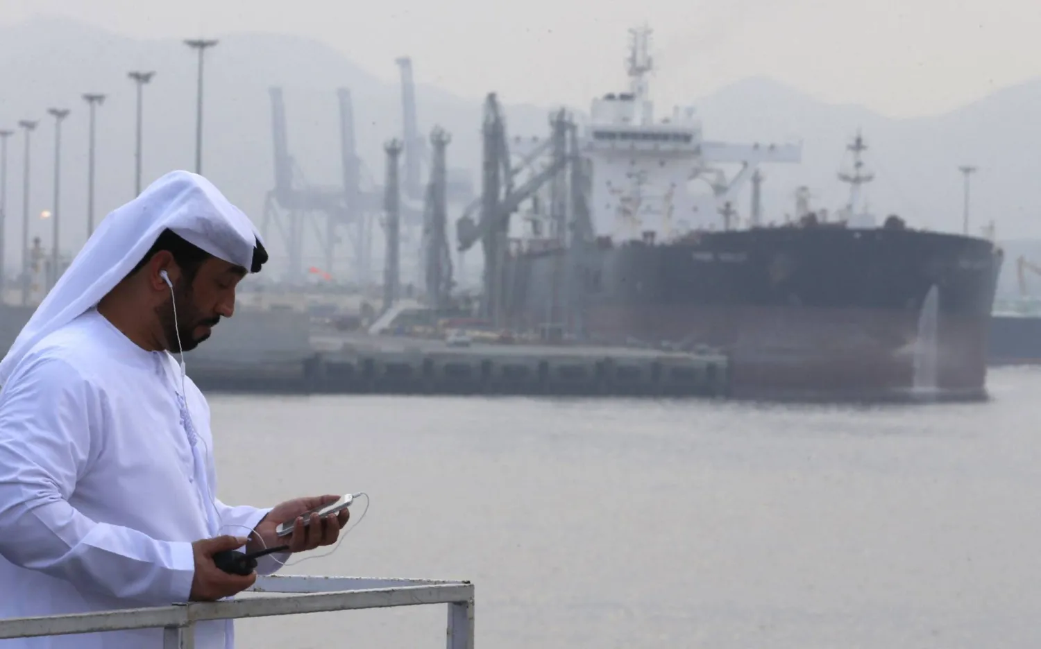 (FILES) An Emirati man stands at the oil terminal of Fujairah during the inauguration ceremony of a dock for supertankers on September 21, 2016. (Photo by Karim SAHIB / AFP)