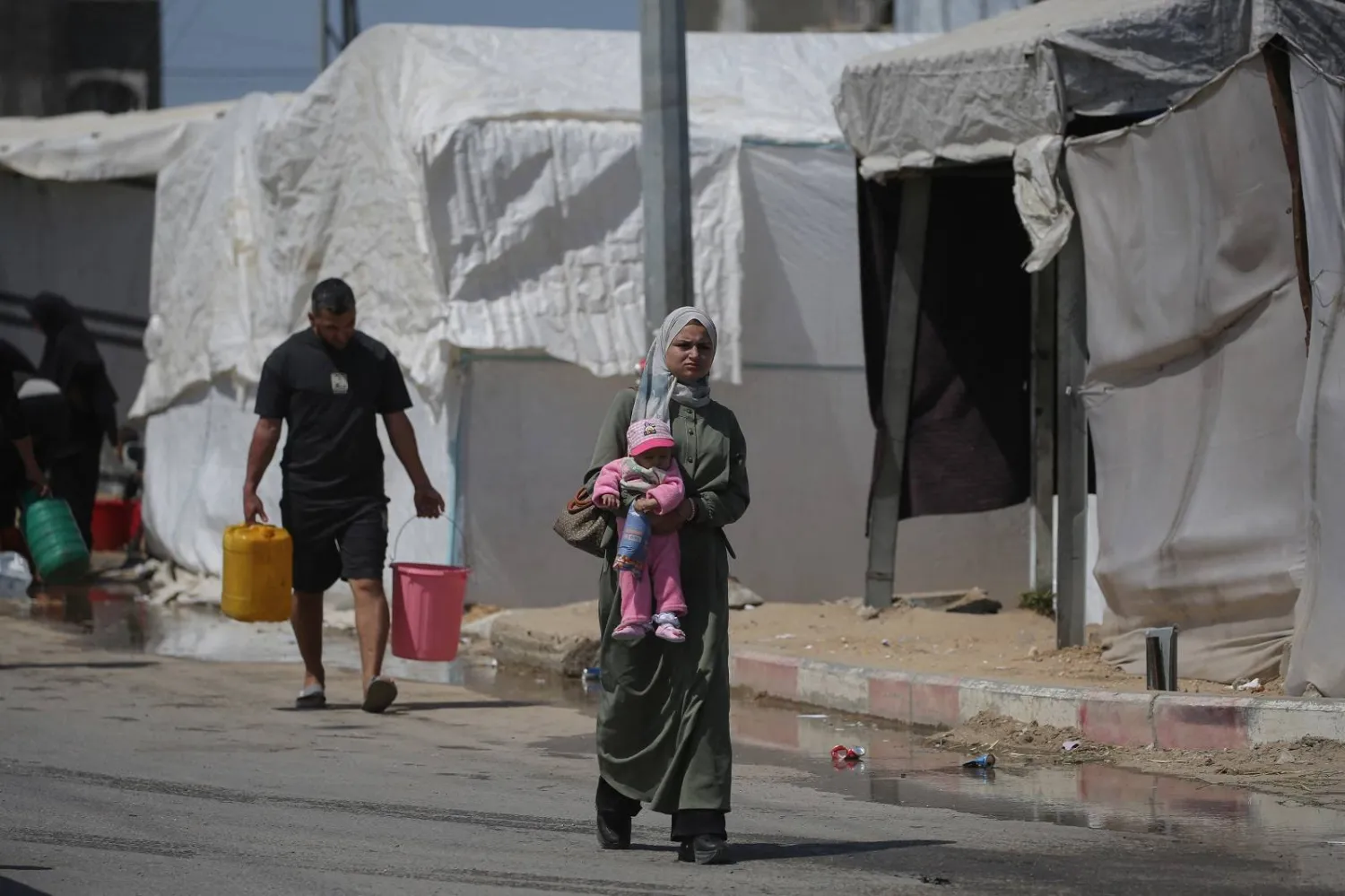 Palestinians fetch drinking water in Al-Bureij Palestinian refugee camp in the central Gaza Strip (AFP)