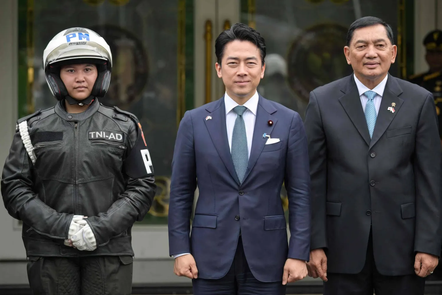  Indonesia's Defense Minister Sjafrie Sjamsoeddin (R), Japan's Defense Minister Shinjiro Koizumi (C), and a female military police officer pose for a photo at the Defense Ministry office in Jakarta on May 4, 2026. (AFP) 