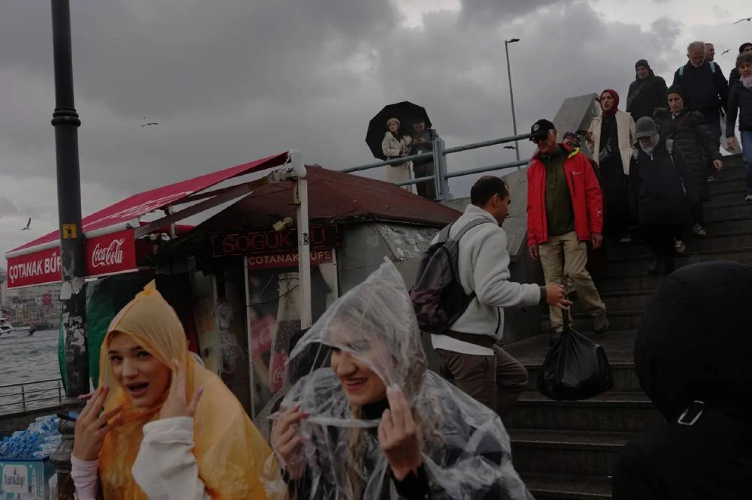 Passers-by walk at Galata bridge on a rainy spring day in Istanbul, Türkiye, Saturday, May 2, 2026. (AP) 