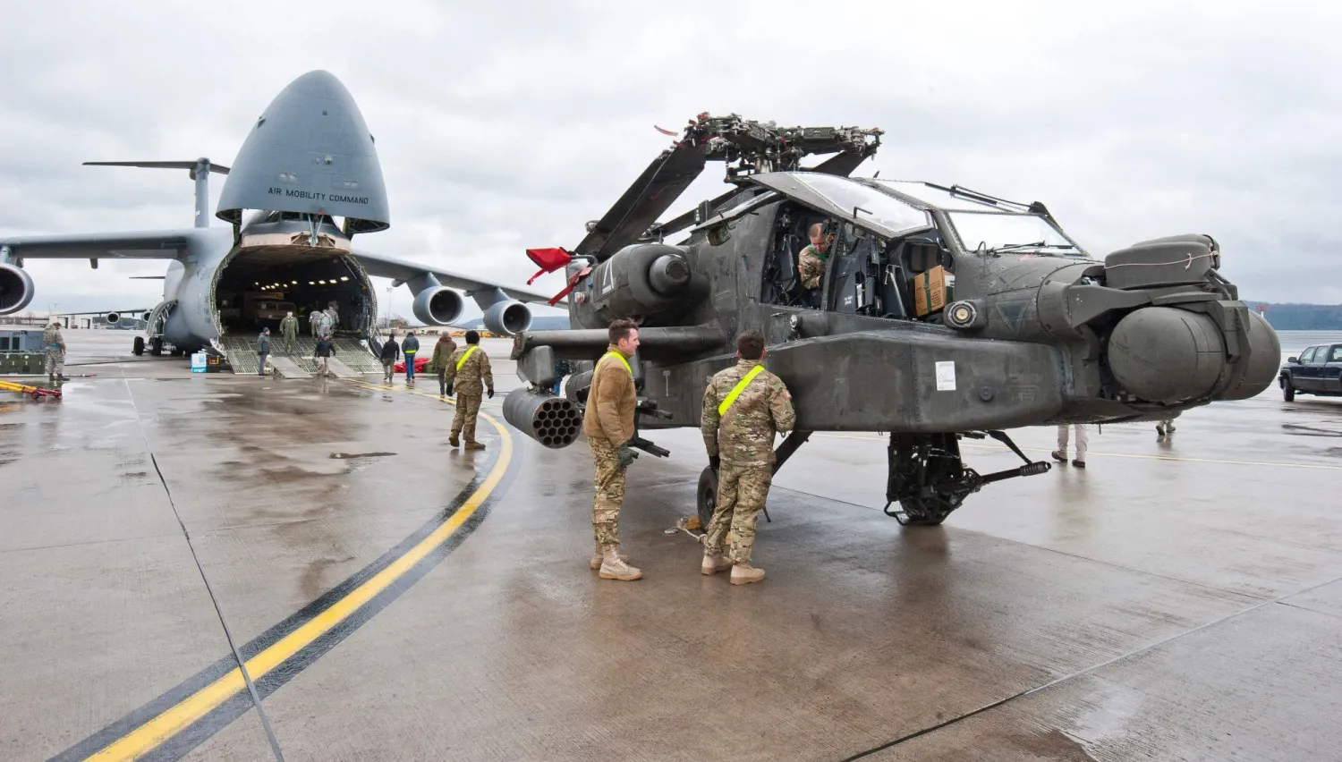An AH-64 Apache attack helicopter stands in front of a Galaxy C-5 transport plane at the US Air Base in Ramstein, western Germany, on February 22, 2017. (dpa/AFP)