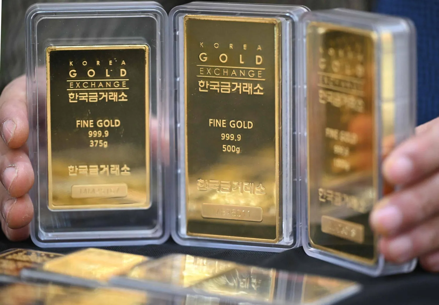 An employee displays gold bars at the Korea Gold Exchange store in Seoul (AFP)
