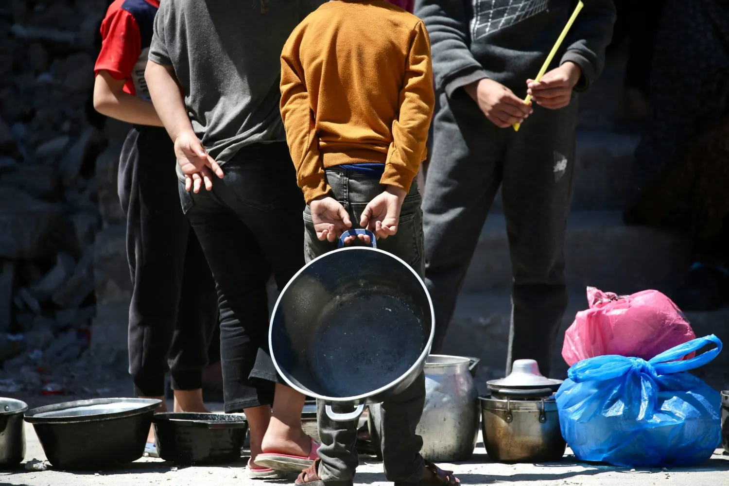 يصطفّ فلسطينيون نازحون لتلقّي حصص غذائية من مطبخ خيري في مخيم البريج للاجئين وسط قطاع غزة (أ.ف.ب)