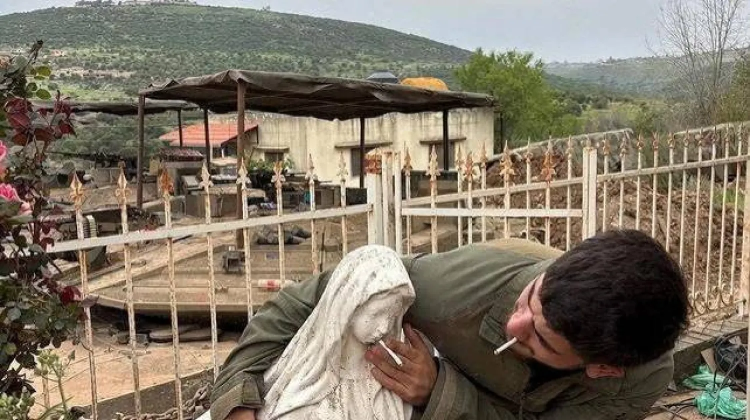 جندي إسرائيلي يضع سيجارة في فم تمثال السيدة العذراء في بلدة دبل بجنوب لبنان (رويترز)