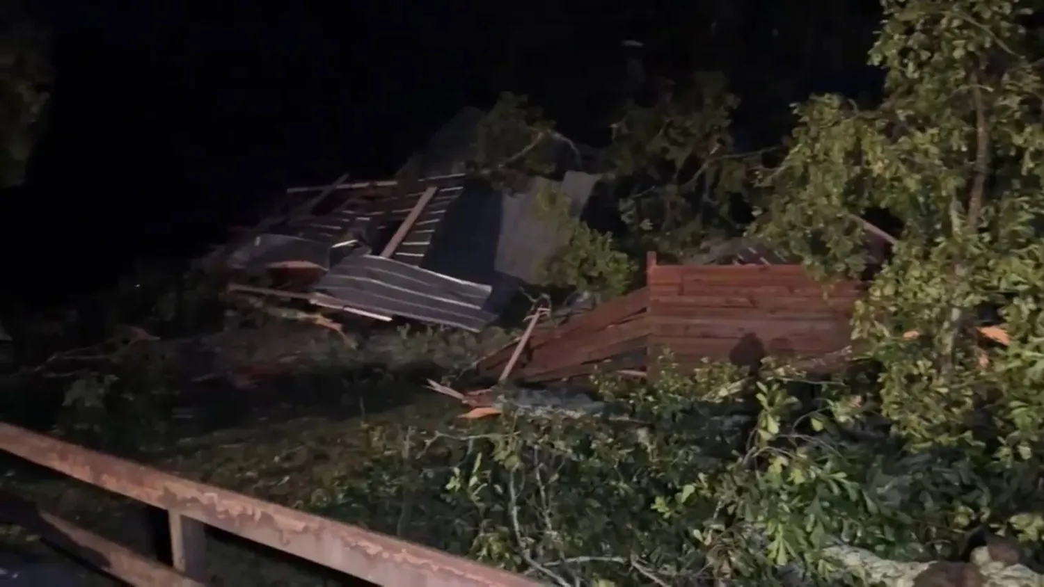In this frame grab from video taken by WDAM, damaged trees and a house or structure following a storm that tore through part of Lamar County, Mississippi, Wednesday, May 6, 2026. (WDAM via AP)