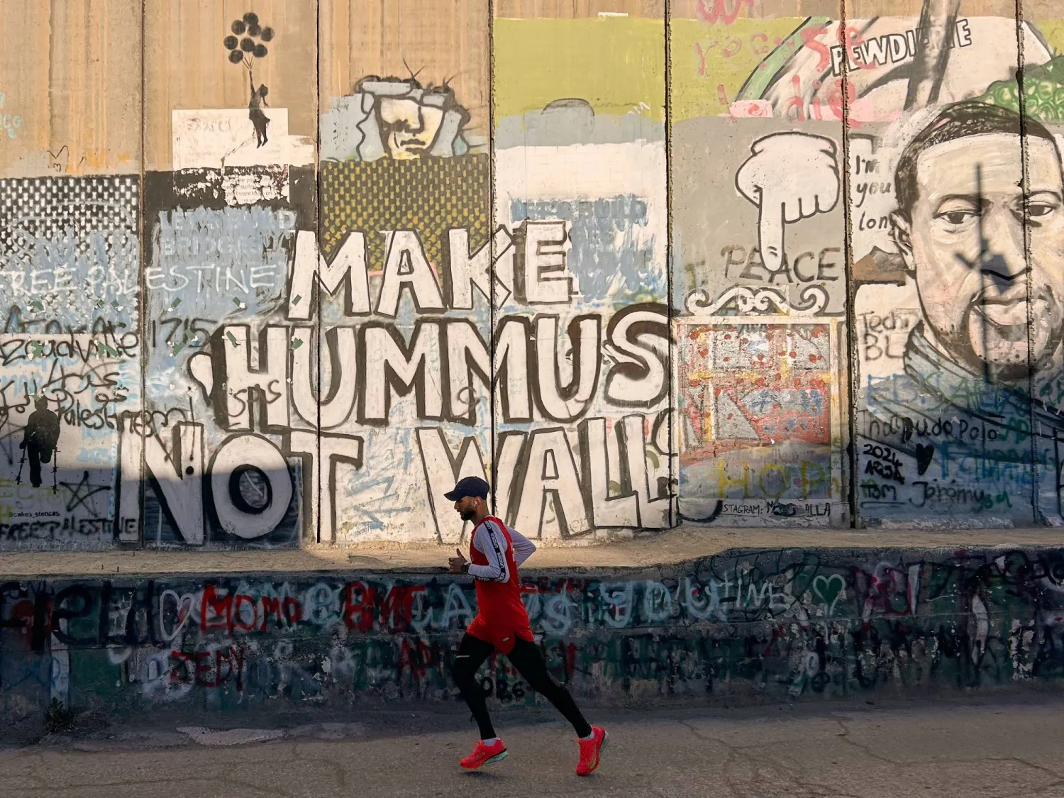  Palestinian Mohamad Al-Assi, who was released from Israeli detention six months ago, runs past Israel's separation wall as he trains ahead of the Palestine Marathon in the West Bank city of Bethlehem, Thursday, May 7, 2026. (AP) 