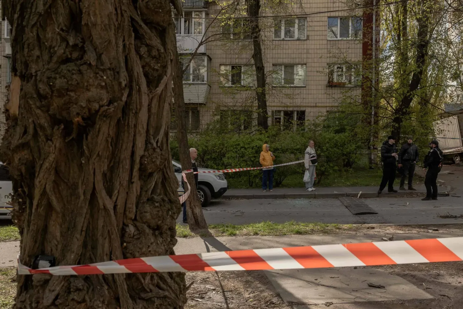Kiev'de Rusya tarafından İHA ile saldırı düzenlenen bir bölgede Ukrayna polisi ve yerel halk, 28 Nisan 2026 (AFP)