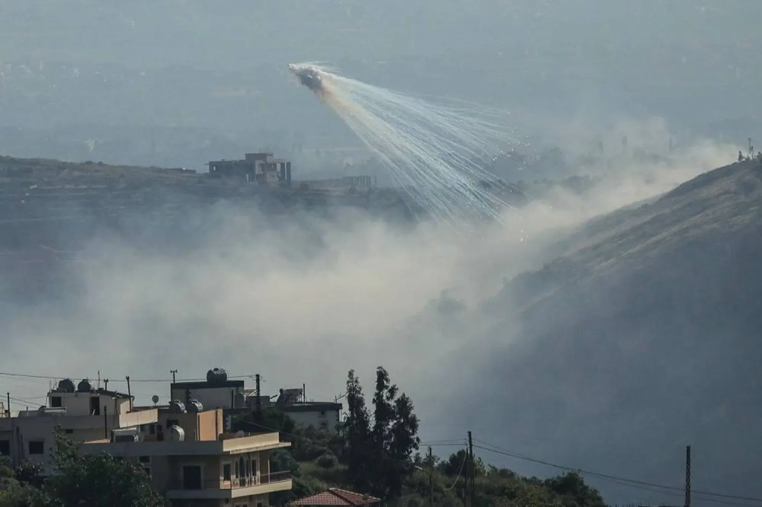 A photograph taken from the southern area of Marjeyoun shows trails of smoke during Israeli shelling on the outskirts of the village of Yohmor on May 10, 2026. (AFP)