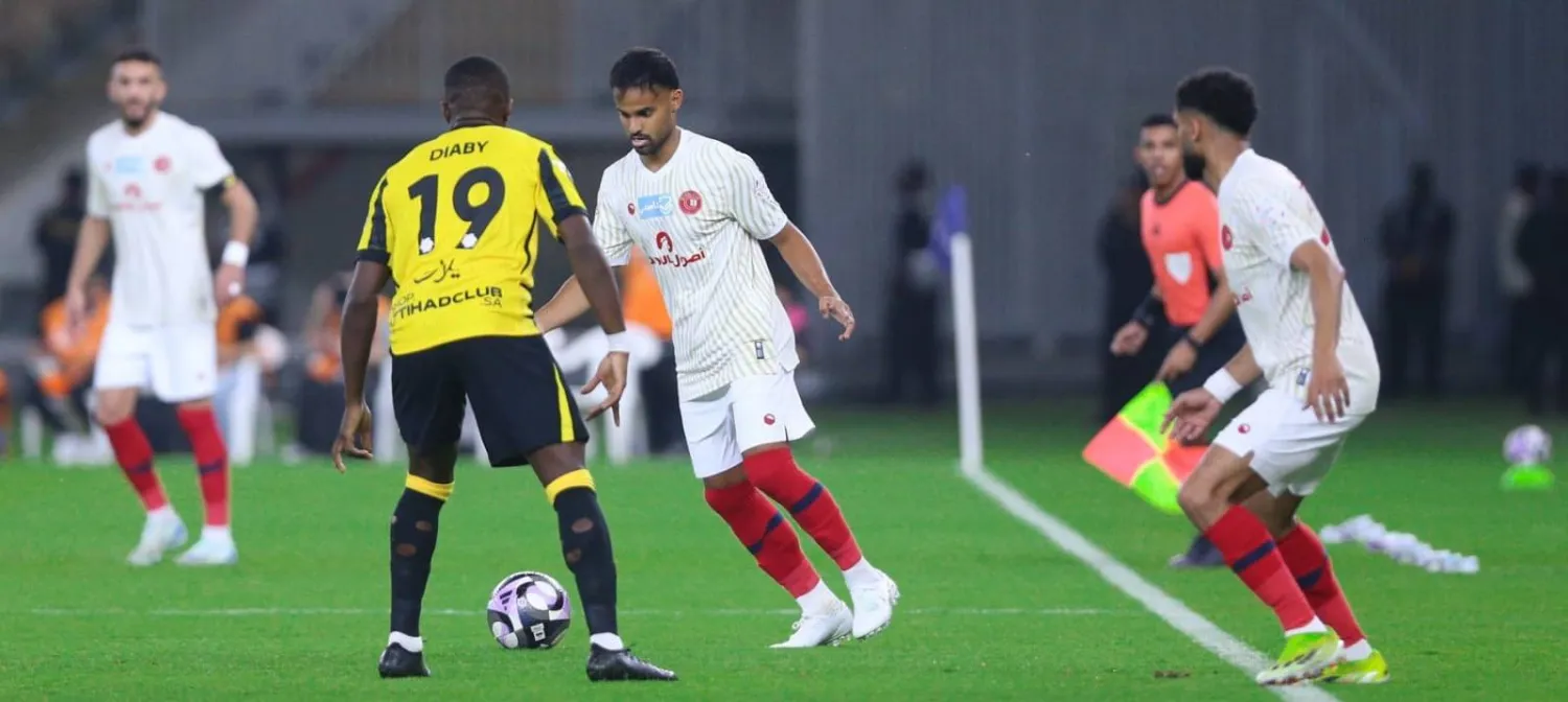 طارق عبدالله يحاول المرور من ديابي لاعب الاتحاد (موقع نادي ضمك)