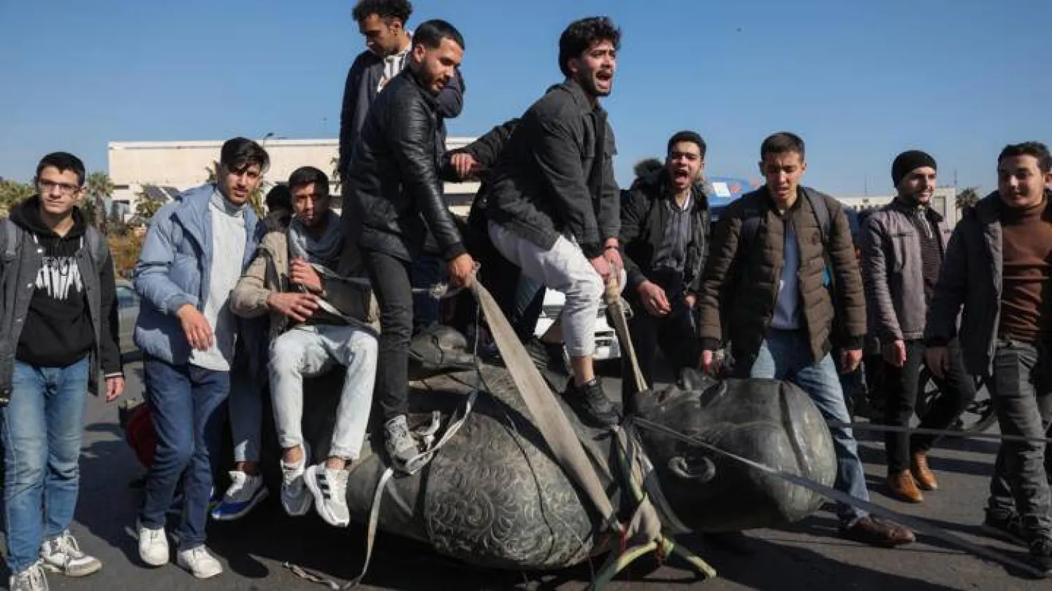Students stand on the toppled statue of late president Hafez al-Assad during a rally near the campus of the Damascus University in the Syrian capital on December 15, 2024. Omar Haj Kadour, AFP
