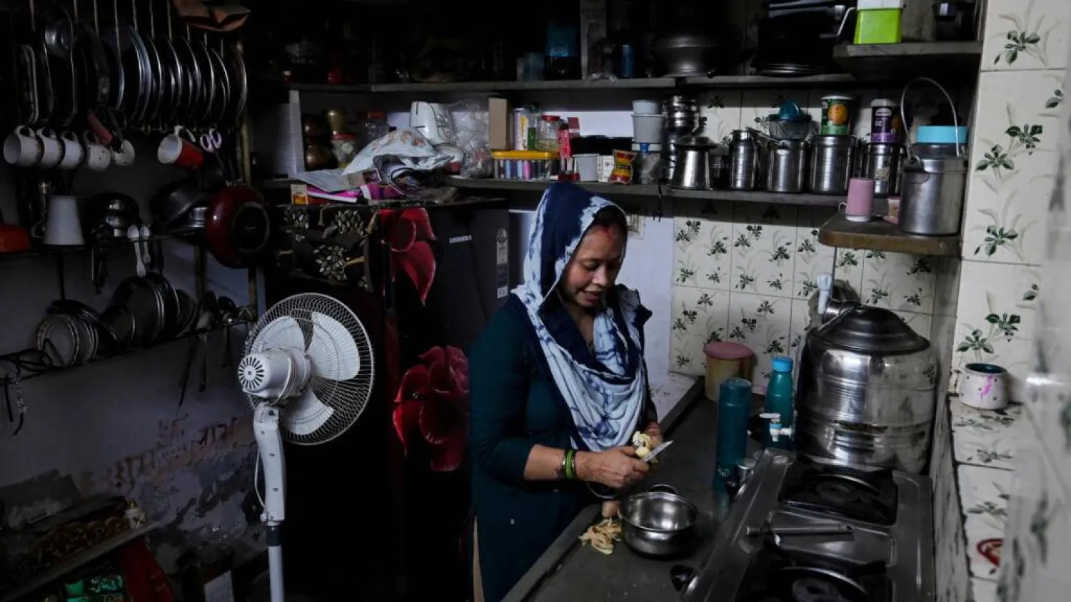 Rakhi Gulshan Singh, a seamstress and policyholder of a heat insurance scheme, preparing a meal inside her single-room rented home in Ahmedabad. Shammi MEHRA / AFP
