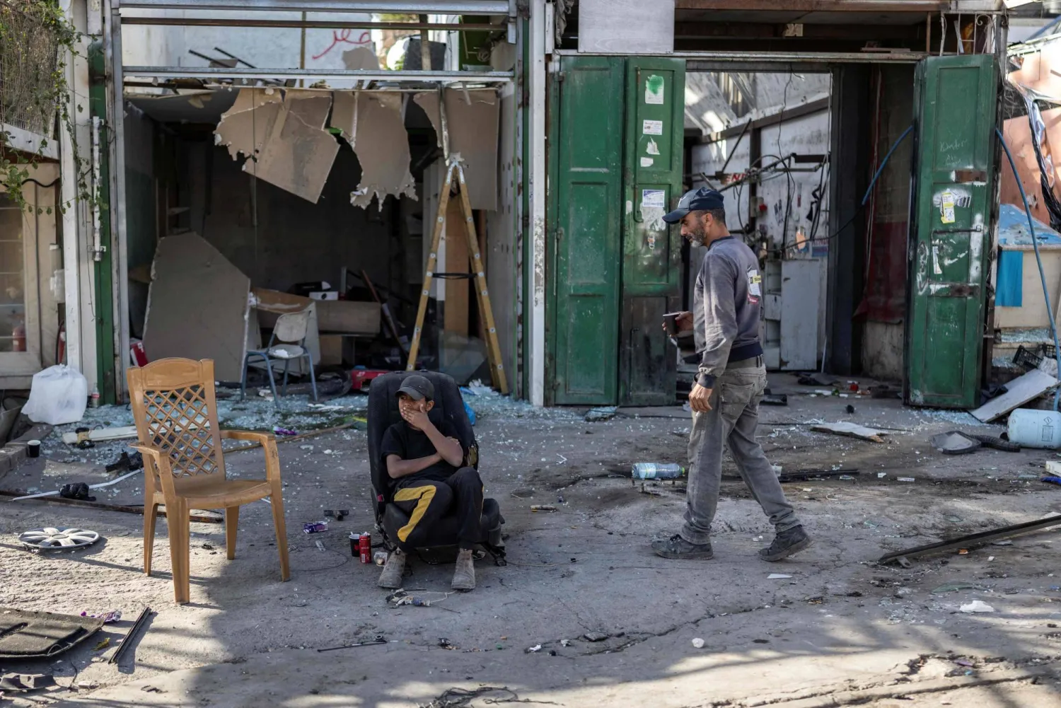 Palestinian workers rest during the demolition of shops before the arrival of an Israeli army demolition team in the occupied Palestinian West Bank town of Al-Eizariya adjacent to East Jerusalem on Sunday (AFP) 