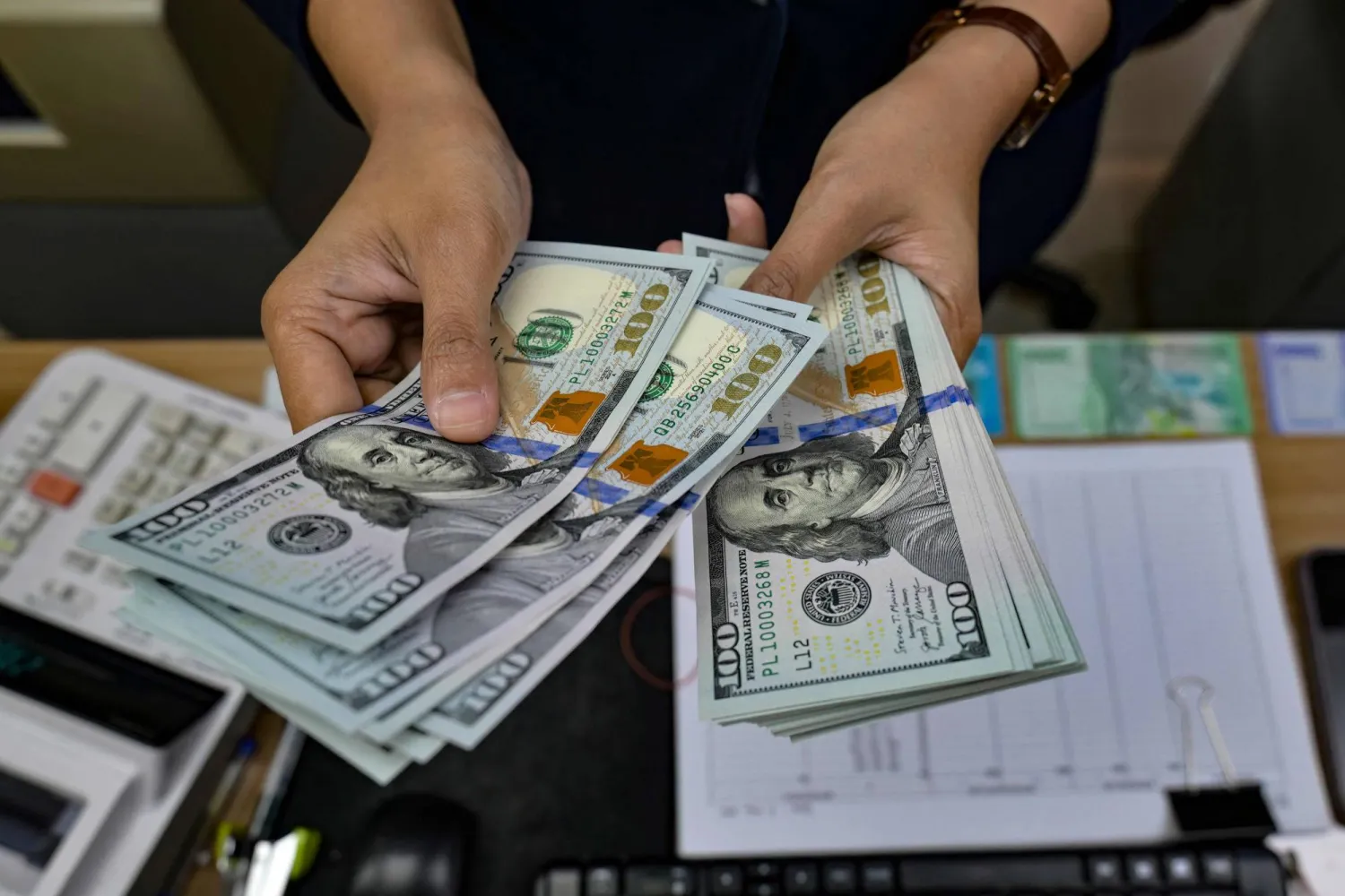  A money changer counts US Dollar notes at a money exchange office in Jakarta on May 12, 2026, amid the Rupiah's depreciation against the USD. (AFP) 