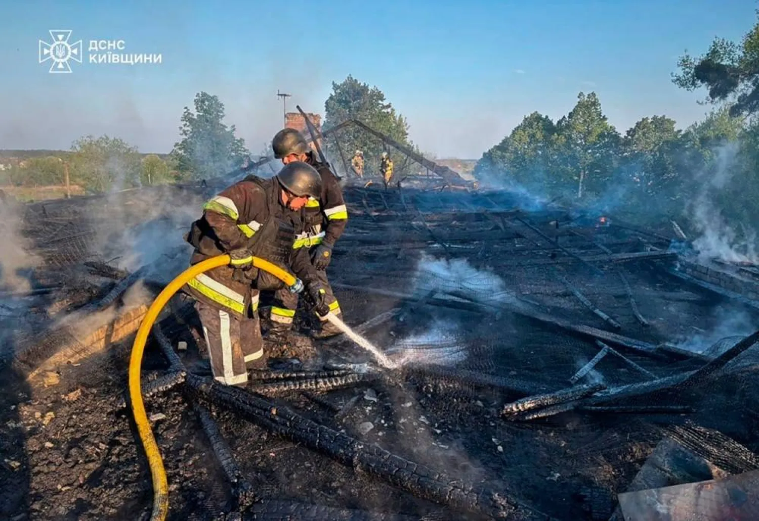  In this photo provided by the Ukrainian Emergency Service, emergency services personnel work to extinguish a fire following a Russian drone attack in Kyiv region, Ukraine, Tuesday, May 12, 2026. (Ukrainian Emergency Service via AP) 