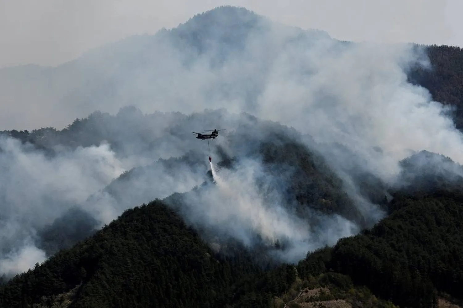 A helicopter conducts firefighting operations as wildfires continue in Otsuchi, Iwate Prefecture, Japan, April 26, 2026. (Reuters) 