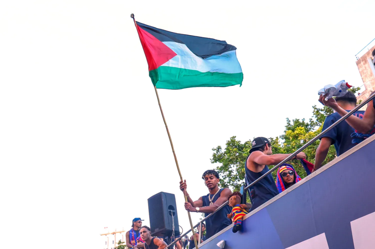 FC Barcelona player Lamine Yamal holds a Palestinian flag as he celebrates with his team atop a bus after winning the Spanish La Liga title in Barcelona, Spain, Monday, May 11, 2026. (AP Photo)