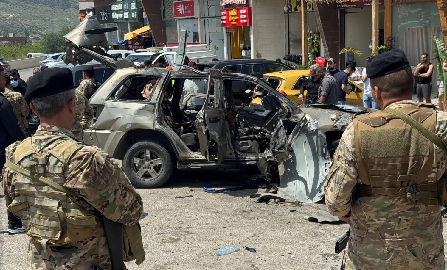 عناصر من الجيش اللبناني في موقع استهداف إسرائيلي لسيارة بمنطقة الجية على أوتوستراد بيروت - الجنوب (رويترز)