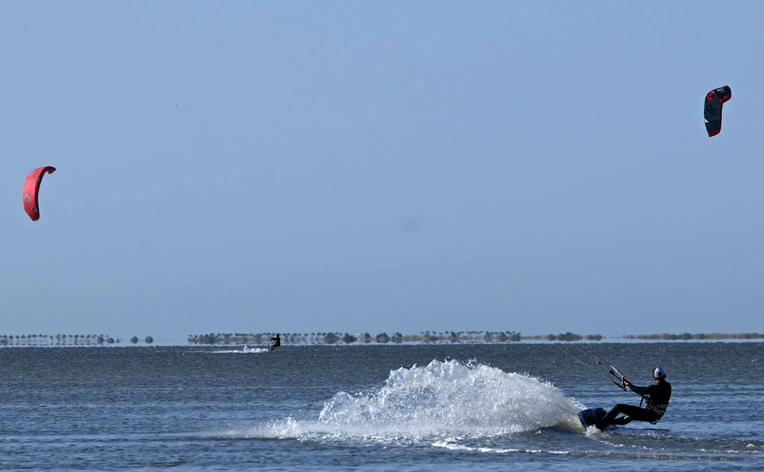  Tourists ride while taking part in kitesurfing in Tunisia's southern island of Djerba on May 5, 2026. (AFP) 