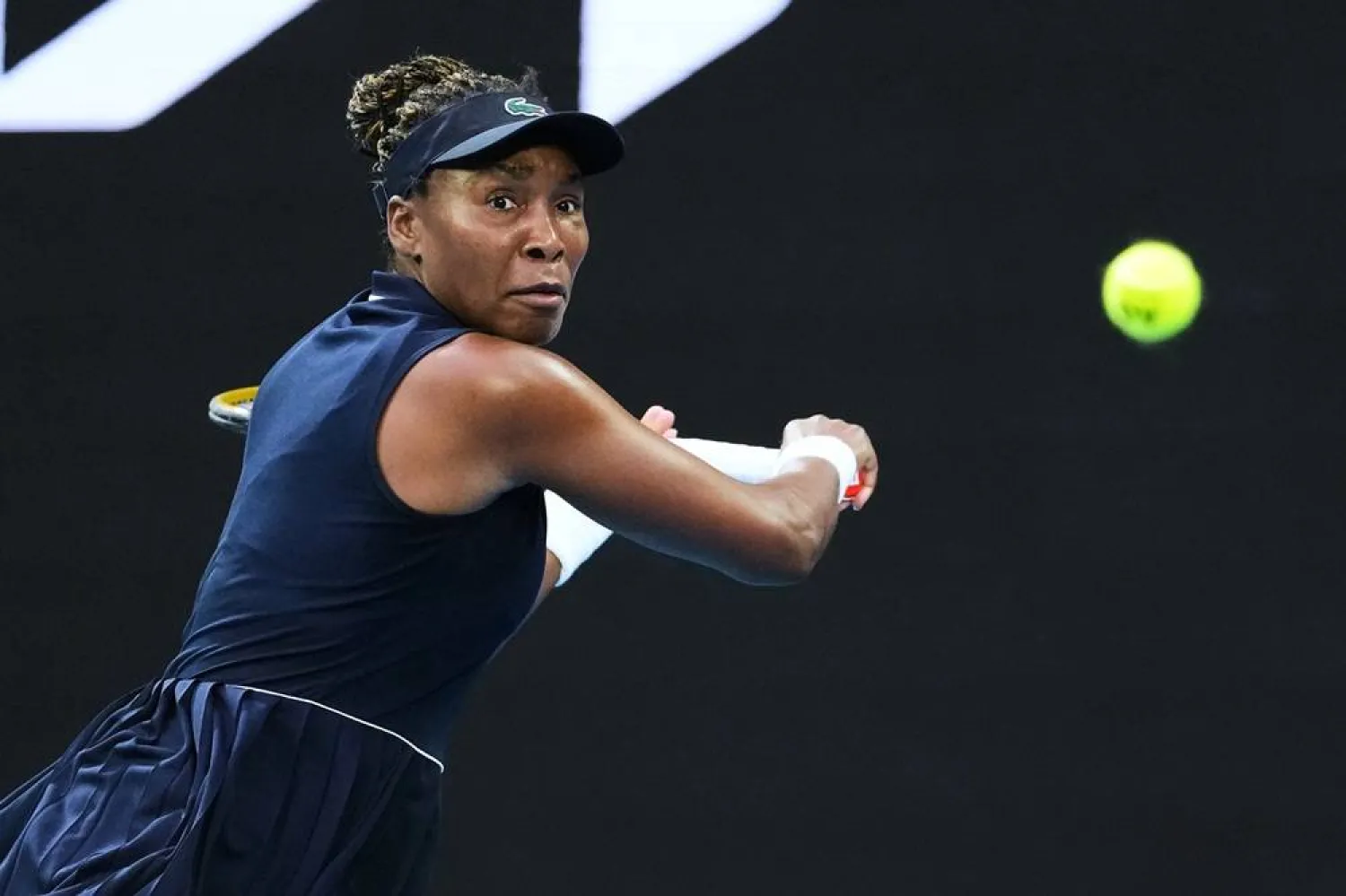 Venus Williams, of the United States, plays a backhand return to Olga Danilovic, of Serbia, during their first round match at the Australian Open tennis championship in Melbourne, Australia, Jan. 18, 2026. (AP)