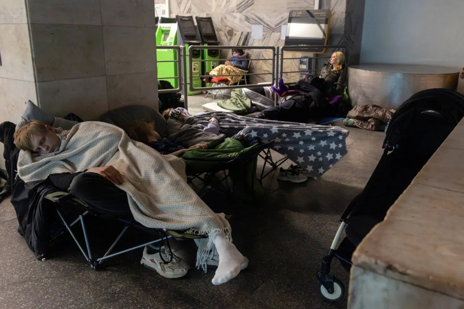 Rusya'nın başkent Kiev'e düzenlediği saldırı sırasında insanlar metro istasyonunda sığınıyor (Reuters)