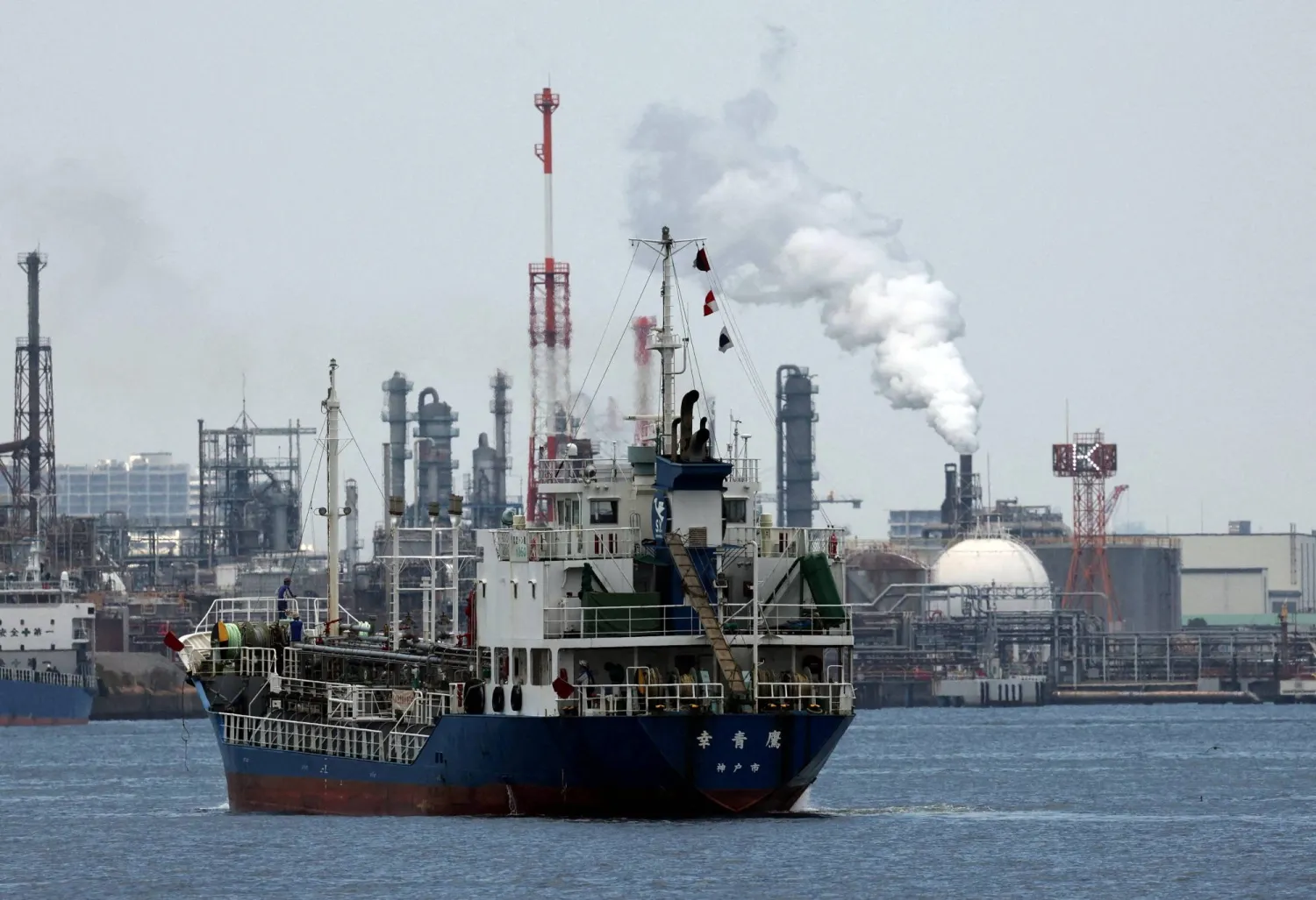 سفينة تبحر قبالة مصفاة نفطية في المنطقة الصناعية بمدينة كاواساكي اليابانية جنوب العاصمة طوكيو (رويترز)