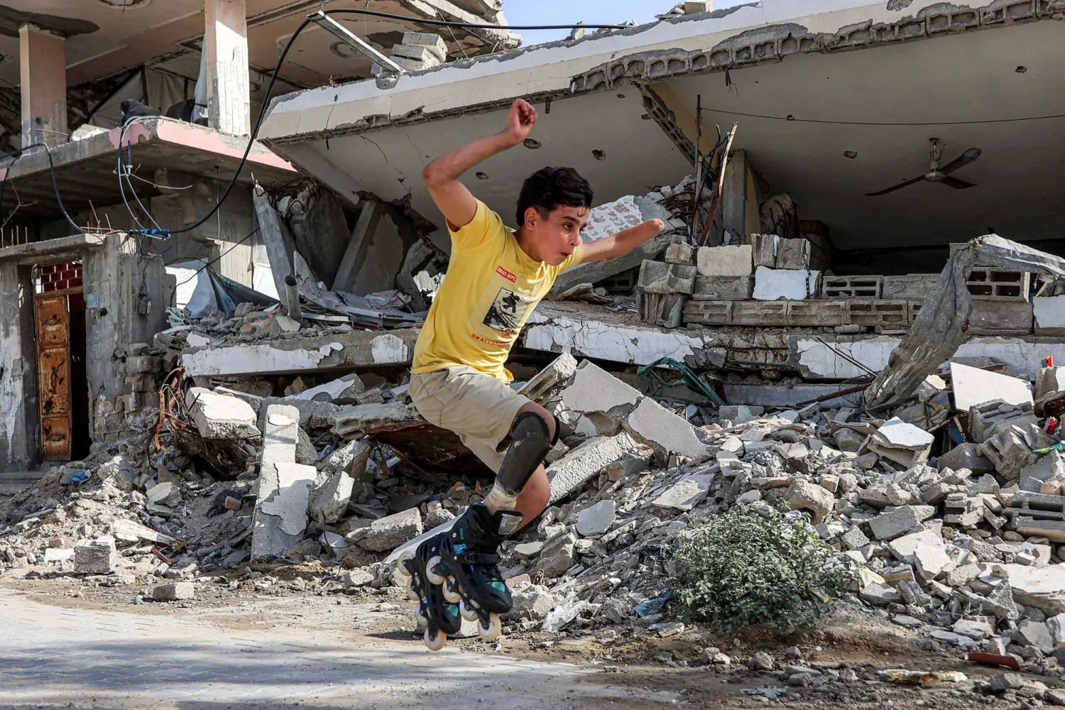 فتى فلسطيني يقفز بعدما تم تركيب «وصلة ساق اصطناعية» له يقفز في أحد شوارع مدينة غزة الأربعاء (أ.ف.ب)