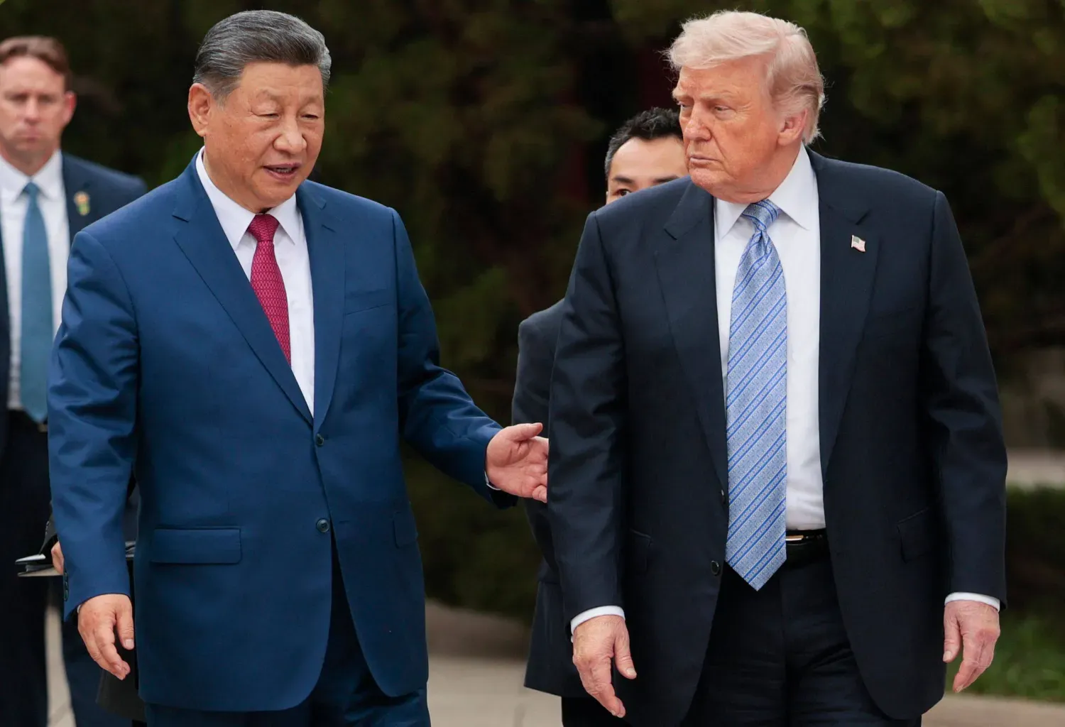 ABD Başkanı Donald Trump (sağda), Pekin'deki Zhongnanhai Parkı'nı ziyaretinin ardından ayrılırken Çin Devlet Başkanı Şi Cinping (solda) ile birlikte yürüyor (AFP)