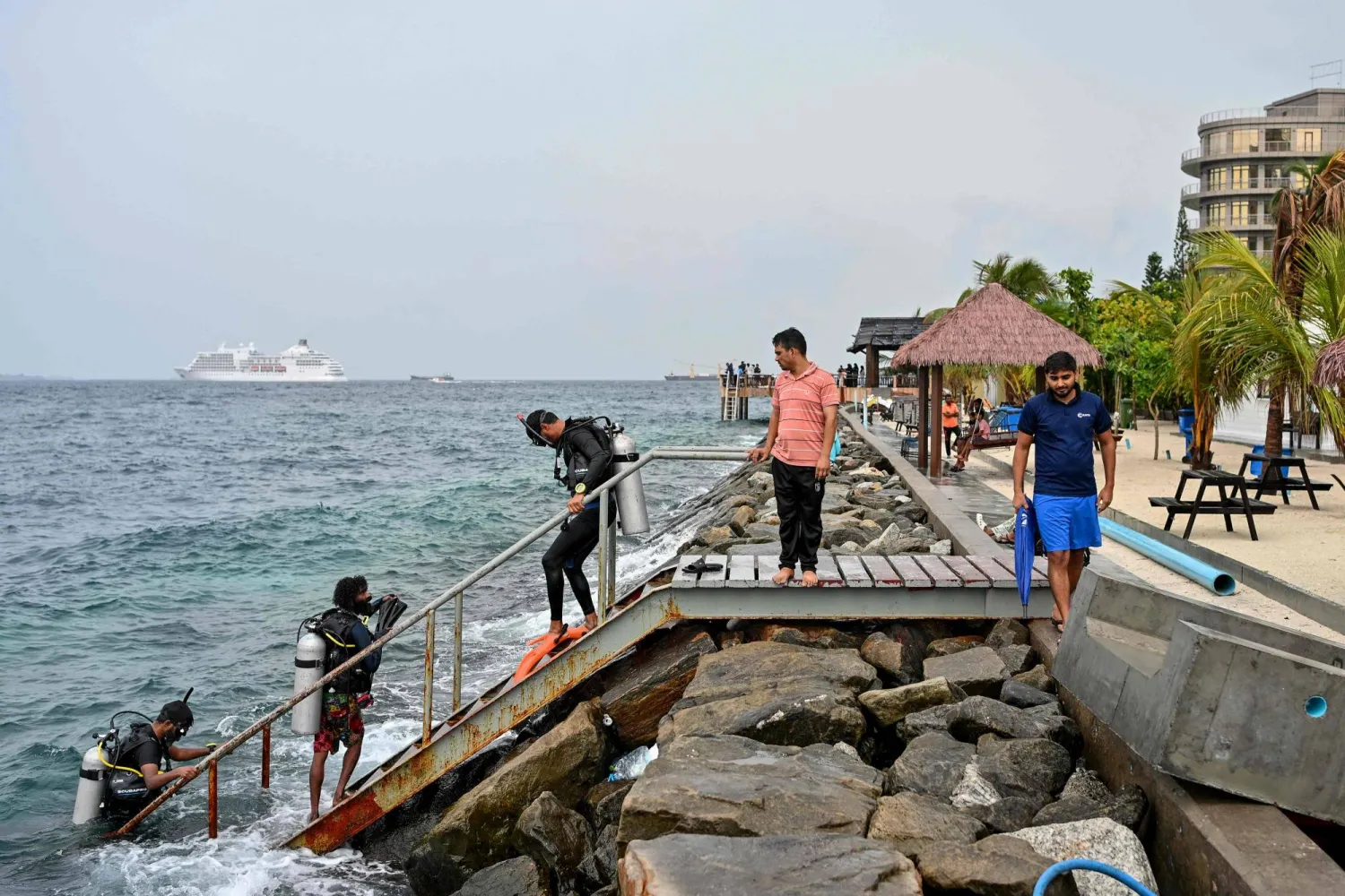 A tourist, along with guides, returns after an open-water diving session near Rasfannu Beach in Malé on May 15, 2026. (Photo by Mohamed Afrah / AFP)