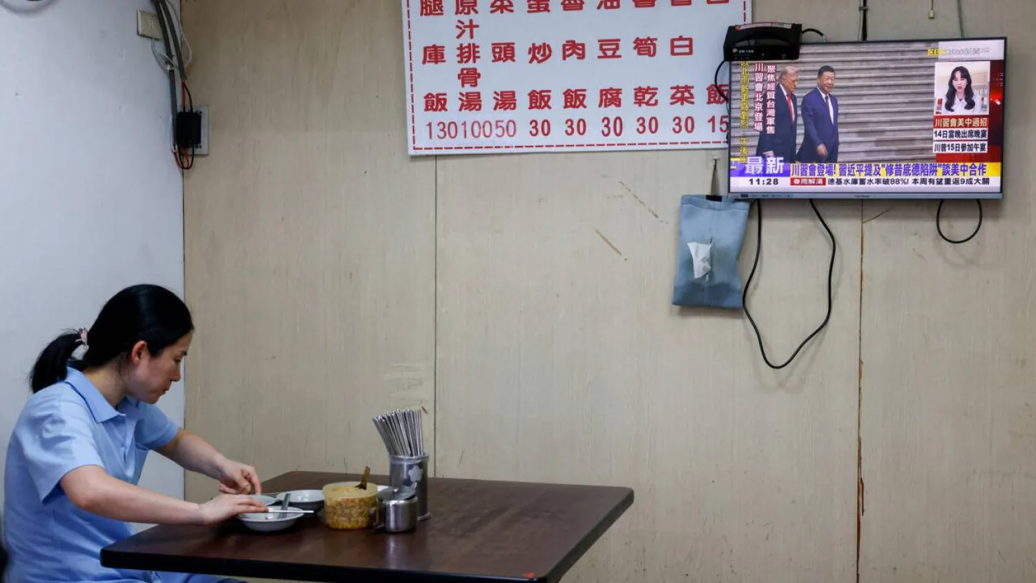 A television screen shows a live broadcast of the meeting between US President Donald Trump and Chinese President Xi Jinping, at a restaurant in Taipei on May 14, 2026. Ann Wang, Reuters
