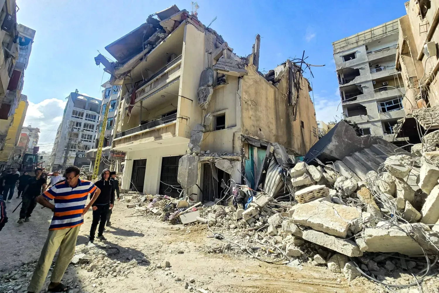Vatandaşlar, İsrail bombardımanı sonucu Sur’daki bazı binalarda meydana gelen hasarı inceliyor, (AFP)