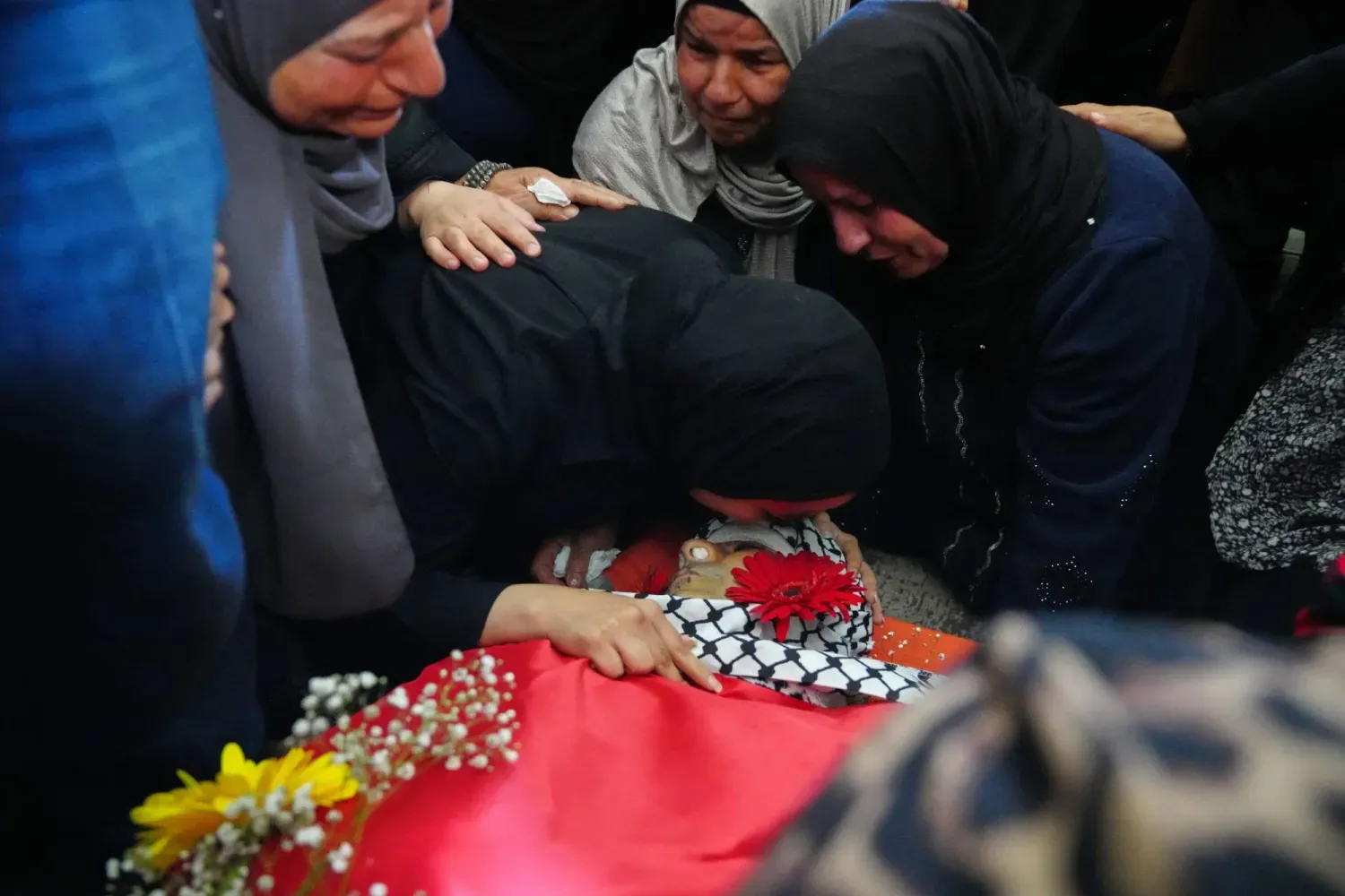 Yas tutanlar, Batı Şeria'daki Deyr Kadis kasabasında düzenlenen cenaze töreninde bir Filistinlinin naaşına son kez bakıyor (AP)