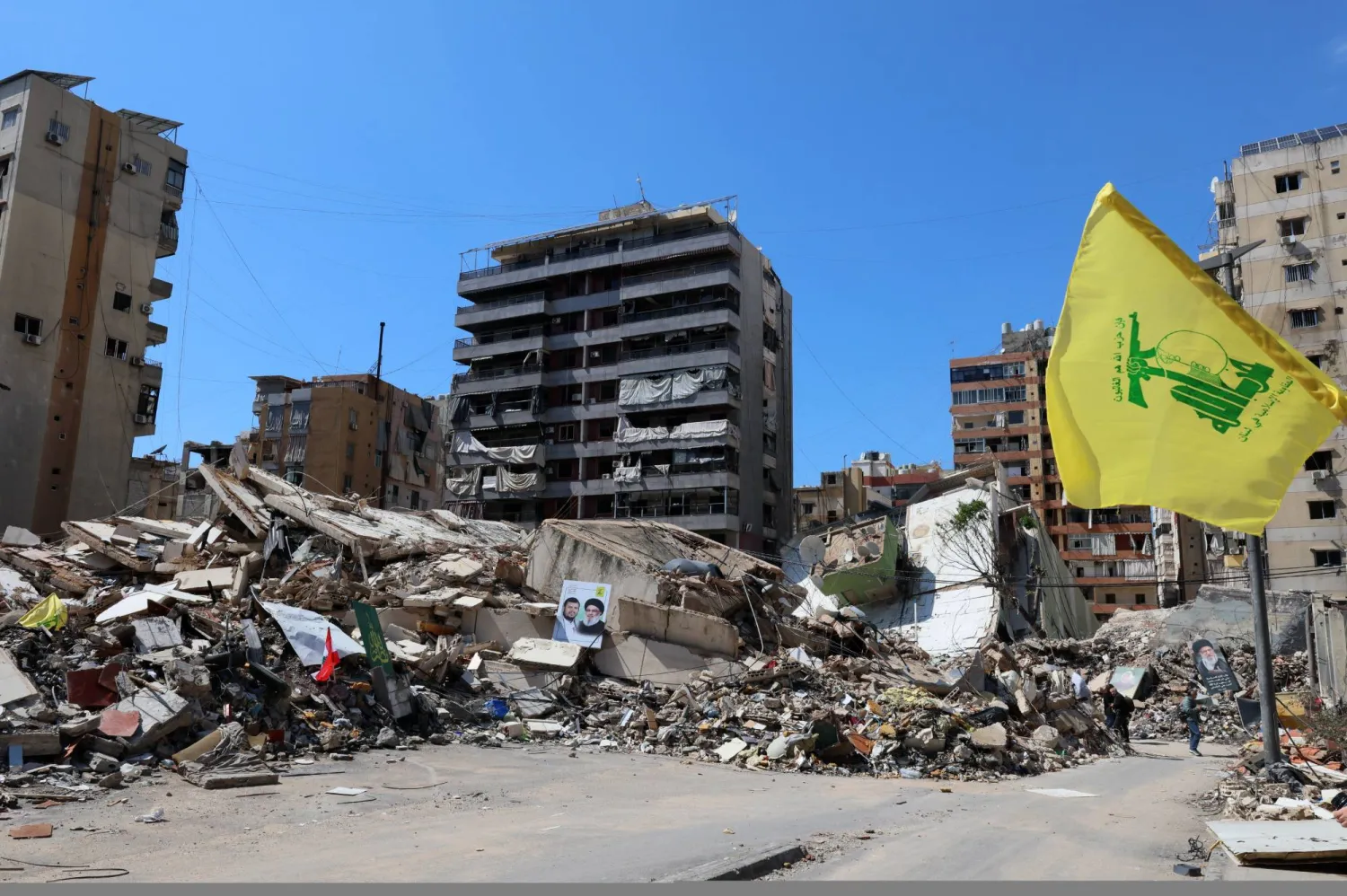 مبانٍ مدمرة نتيجة القصف الإسرائيلي في الضاحية الجنوبية لبيروت حيث يرتفع علم لـ«حزب الله» (إ.ب.أ)
