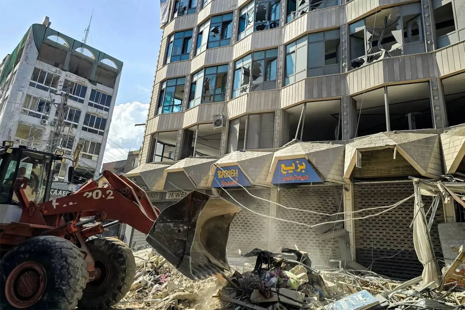 A bulldozer clears debris from outside a damaged building after an overnight Israeli strike on the southern Lebanese city of Tyre (AFP)
