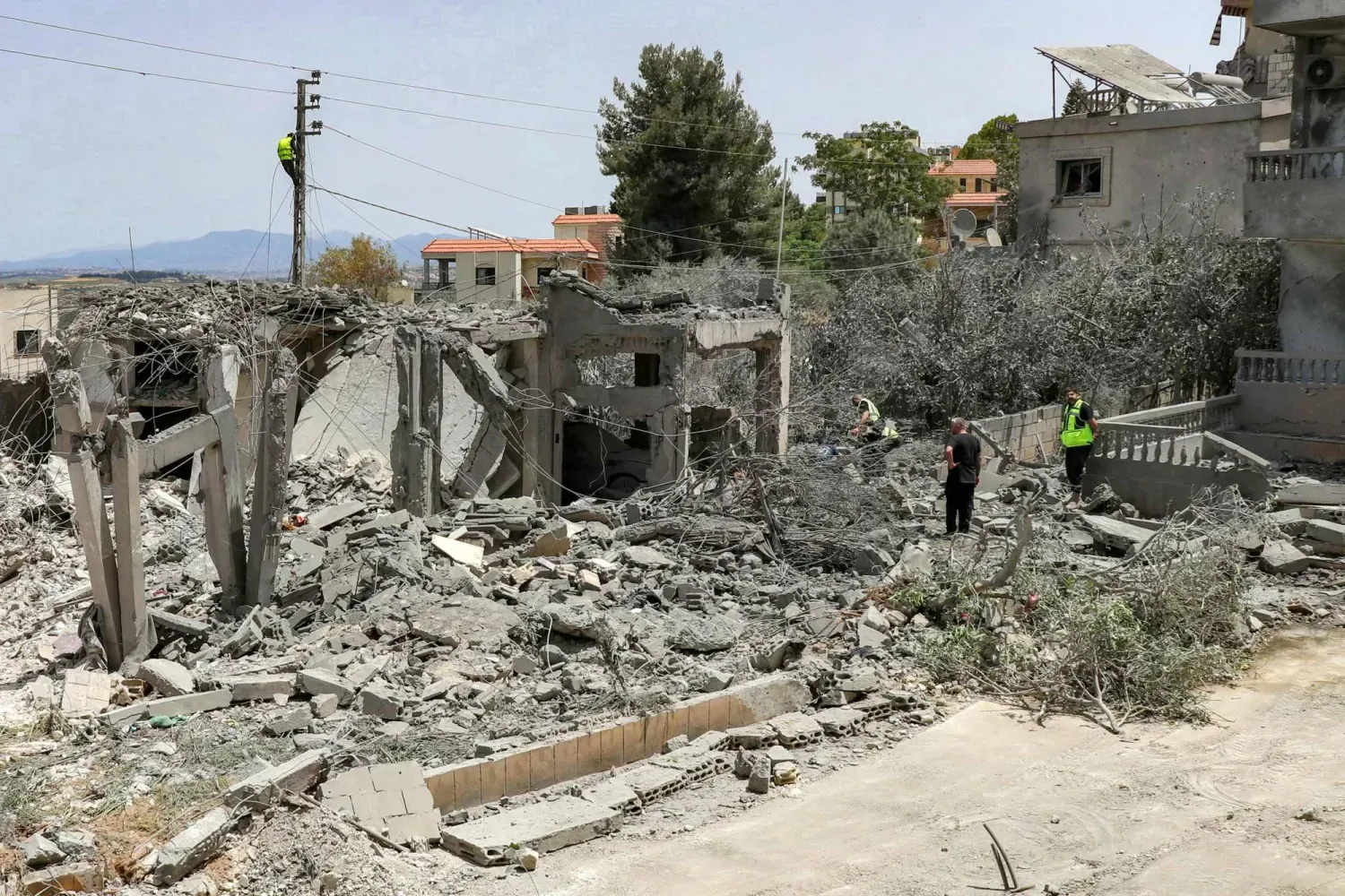 İsrail’in dün Lübnan'ın güneyindeki Deyru'l-Kanun en-Nehir köyüne düzenlediği saldırının geride bıraktığı yıkıntılar arasında çalışan kurtarma ekipleri (AFP)