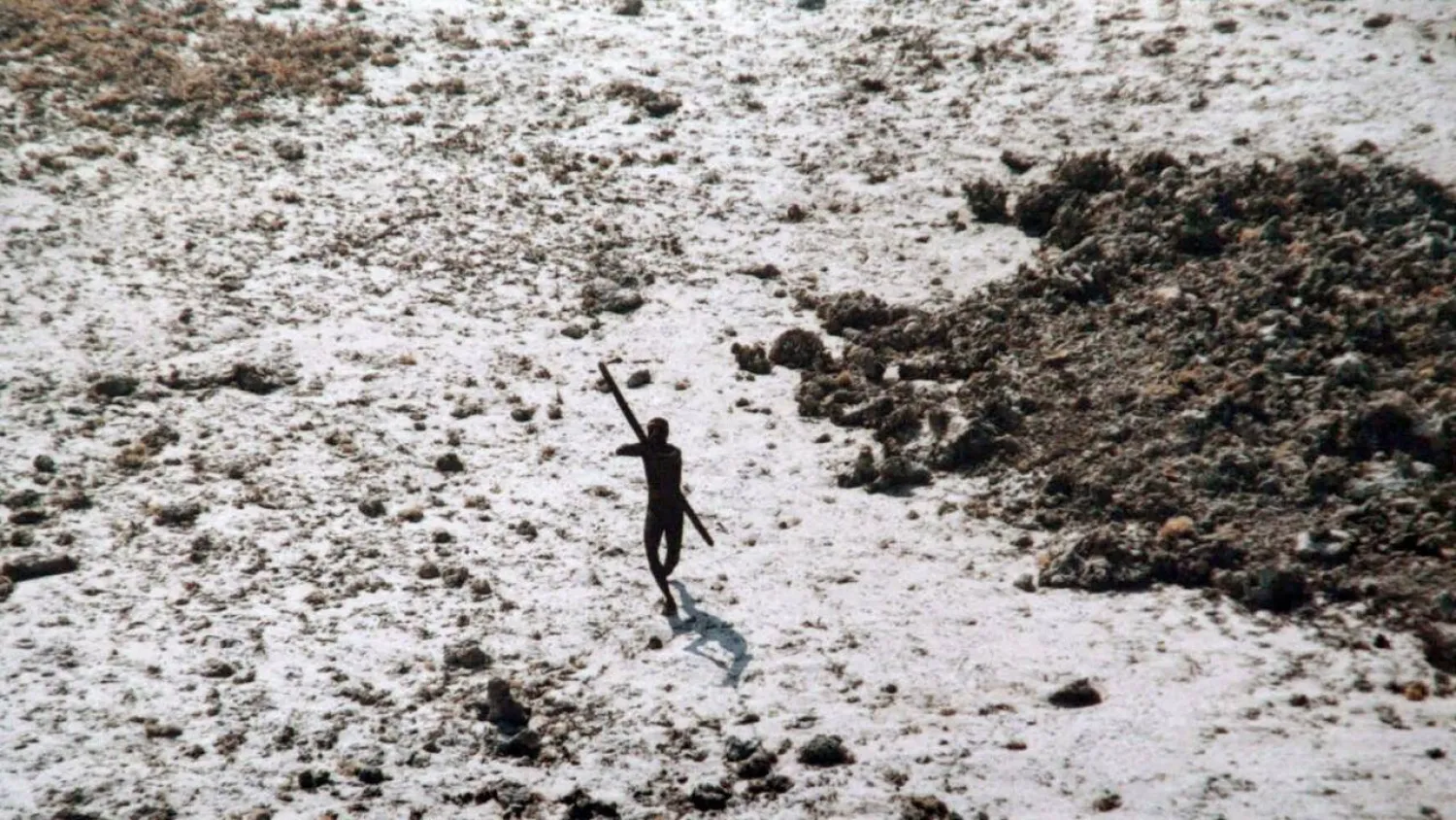 File photo of a man with the Sentinelese tribe aiming his bow and arrow at an Indian Coast Guard helicopter as it flies over North Sentinel Island in the Andaman Islands. Handout / Indian Coast Guard/AFP/File
