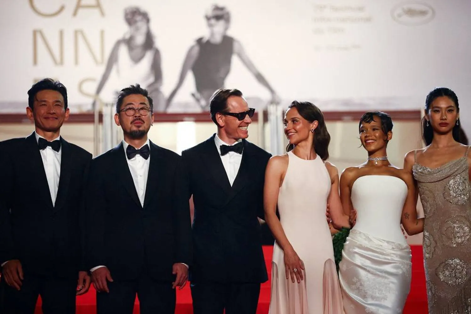 Director Na Hong-jin and cast members Hwang Jung-min, Alicia Vikander, Michael Fassbender, Taylor Russell and Hoyeon pose on the red carpet during arrivals for the screening of the film "Hope" in competition at the 79th Cannes Film Festival in Cannes, France, May 17, 2026. (Reuters) 