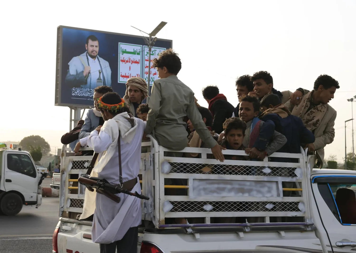 People ride a vehicle driving past a digital billboard featuring Houthi leader Abdul Malik al-Houthi in Sanaa, Yemen, 14 May 2026. (EPA) 