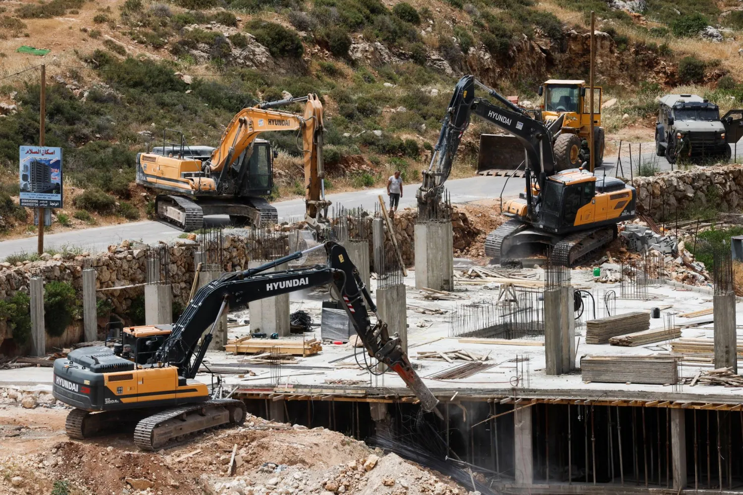 آليات إسرائيلية ثقيلة تهدم مبنى فلسطينياً قرب بيت لحم في الضفة الغربية المحتلة يوم الاثنين (رويترز)