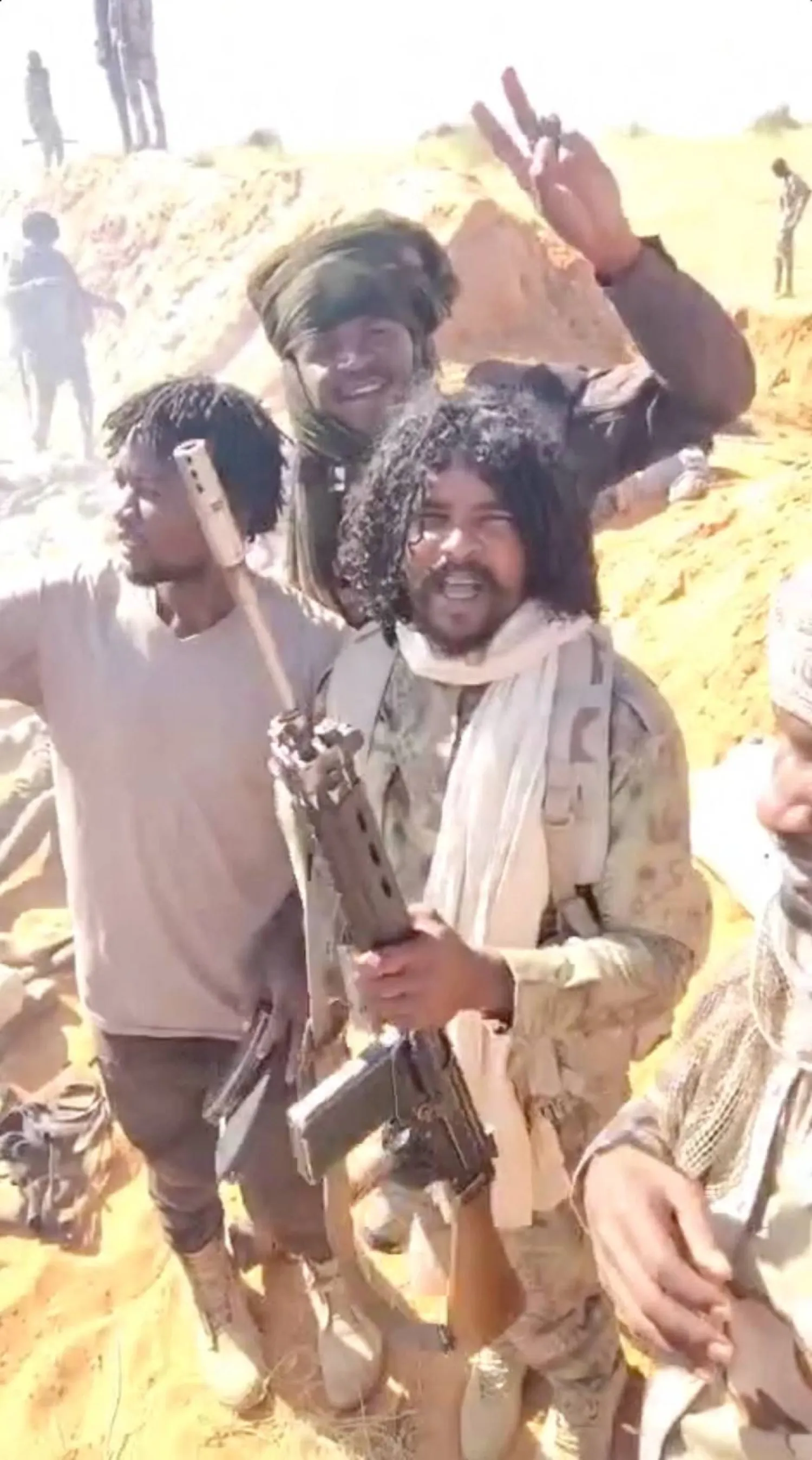 القائد الميداني في «الدعم السريع» الفاتح عبد الله إدريس الشهير بـ«أبو لولو» يتوسط مقاتلين آخرين قرب الفاشر يوم 27 أكتوبر 2025 (لقطة مقتطعة من فيديو - رويترز)