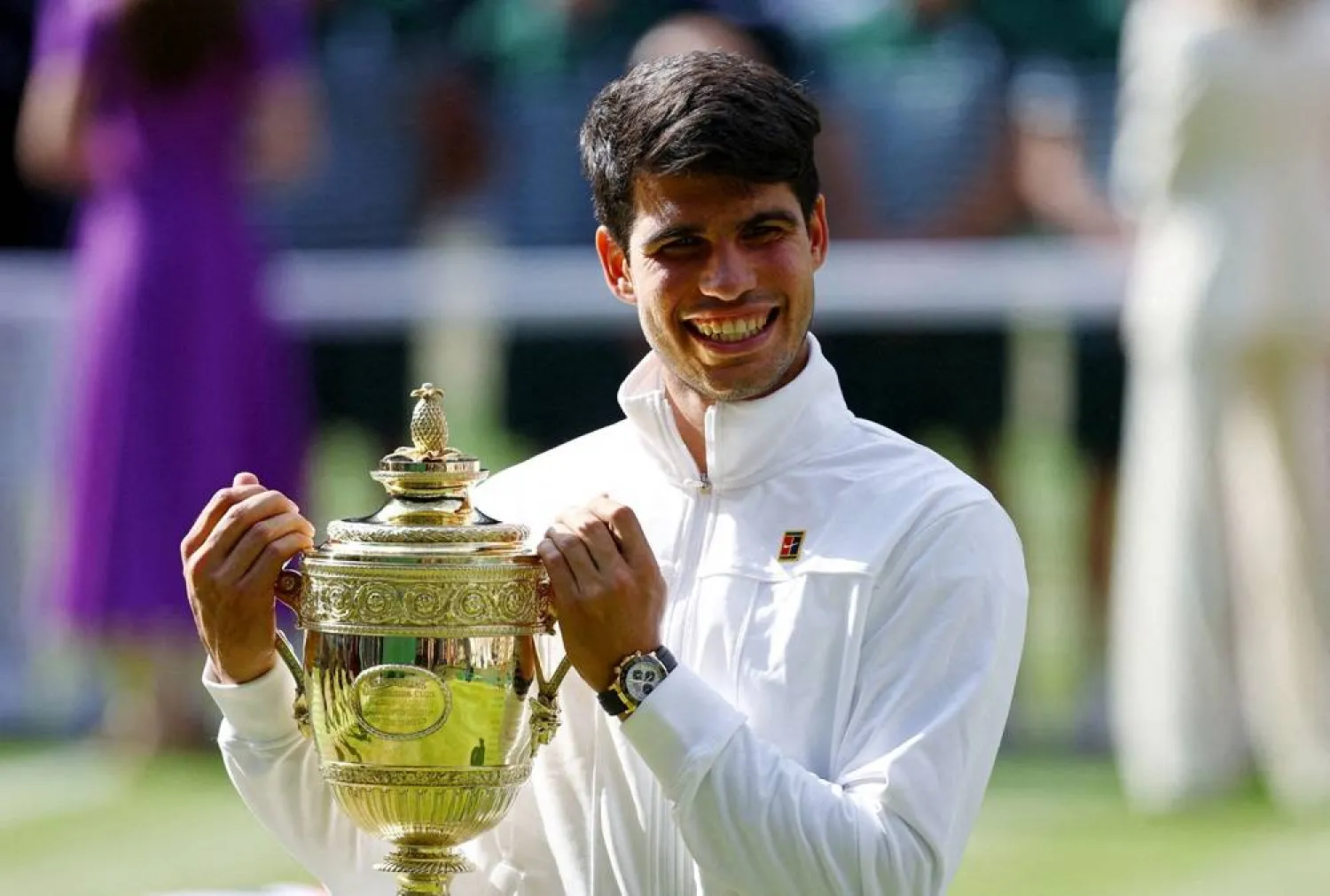 Tennis - Wimbledon - All England Lawn Tennis and Croquet Club, London, Britain - July 14, 2024 Spain's Carlos Alcaraz poses for a picture with the trophy after winning his men's singles final against Serbia's Novak Djokovic. (Reuters)
