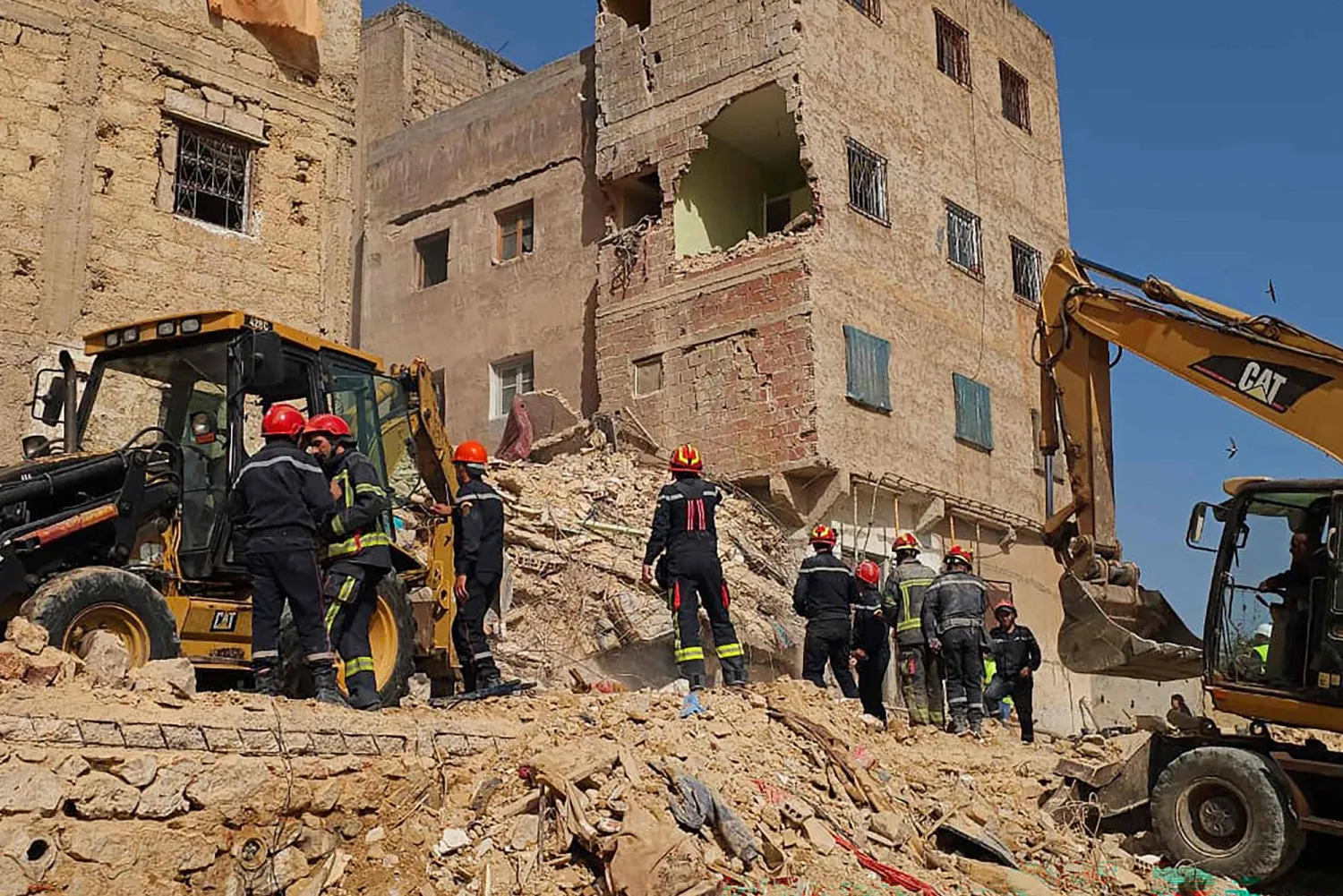 رجال الإنقاذ يبحثون بين أنقاض مبنى مكون من 4 طوابق انهار ليلاً في مدينة فاس المغربية (أ.ف.ب)