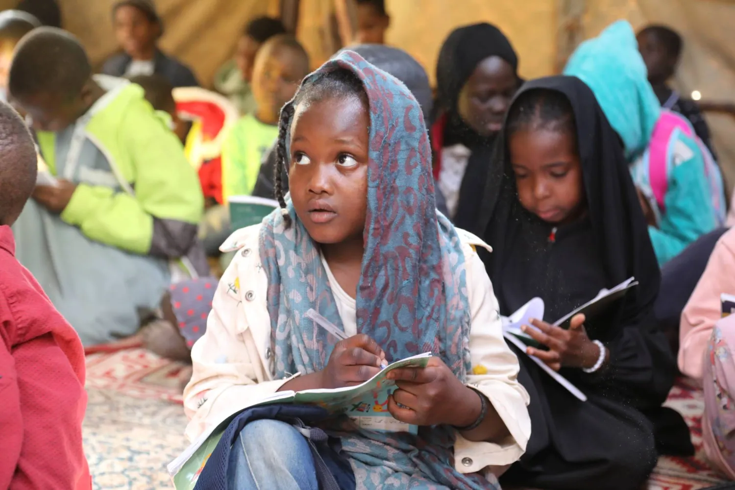 أطفال سودانيون نزحوا مع عائلاتهم إلى ليبيا يتلقون درساً في مدرسة للاجئين في تاجوراء شمال طرابلس (أرشيفية - أ.ب)