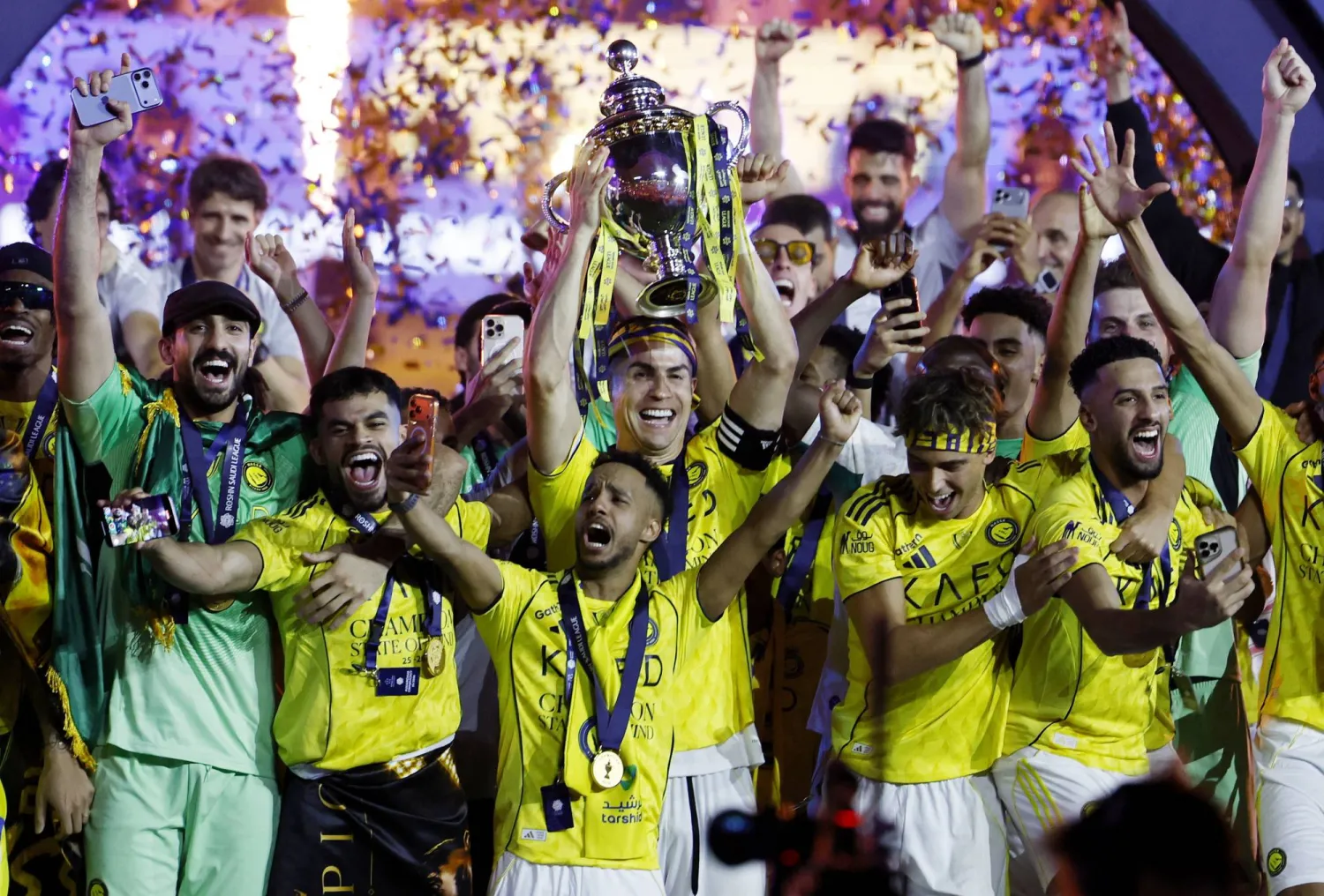 رونالدو يرفع كأس الدوري السعودي عاليا (رويترز)