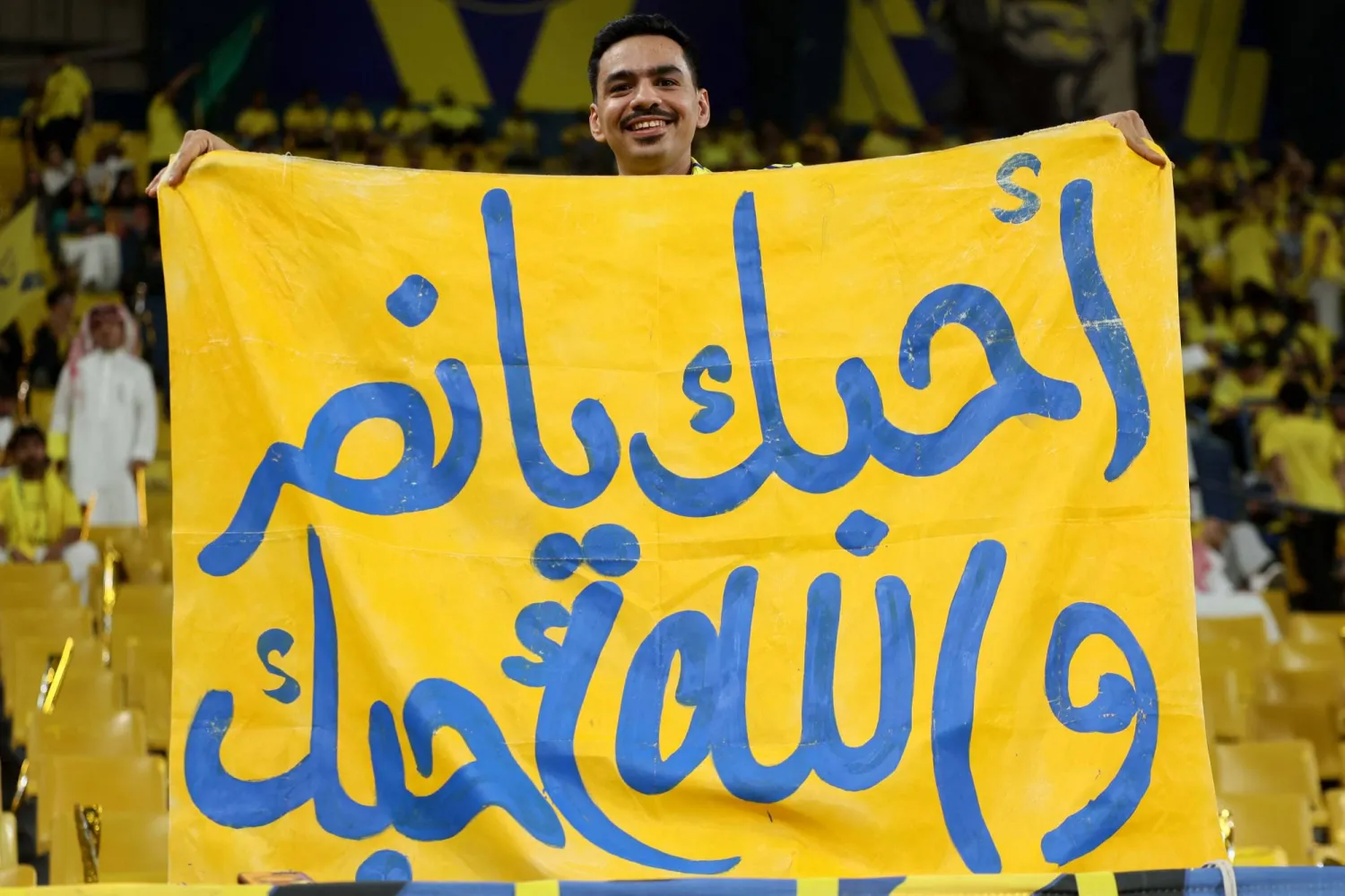 مشجع نصراوي يساند فريقه خلال المباراة أمام ضمك (أ.ف.ب)